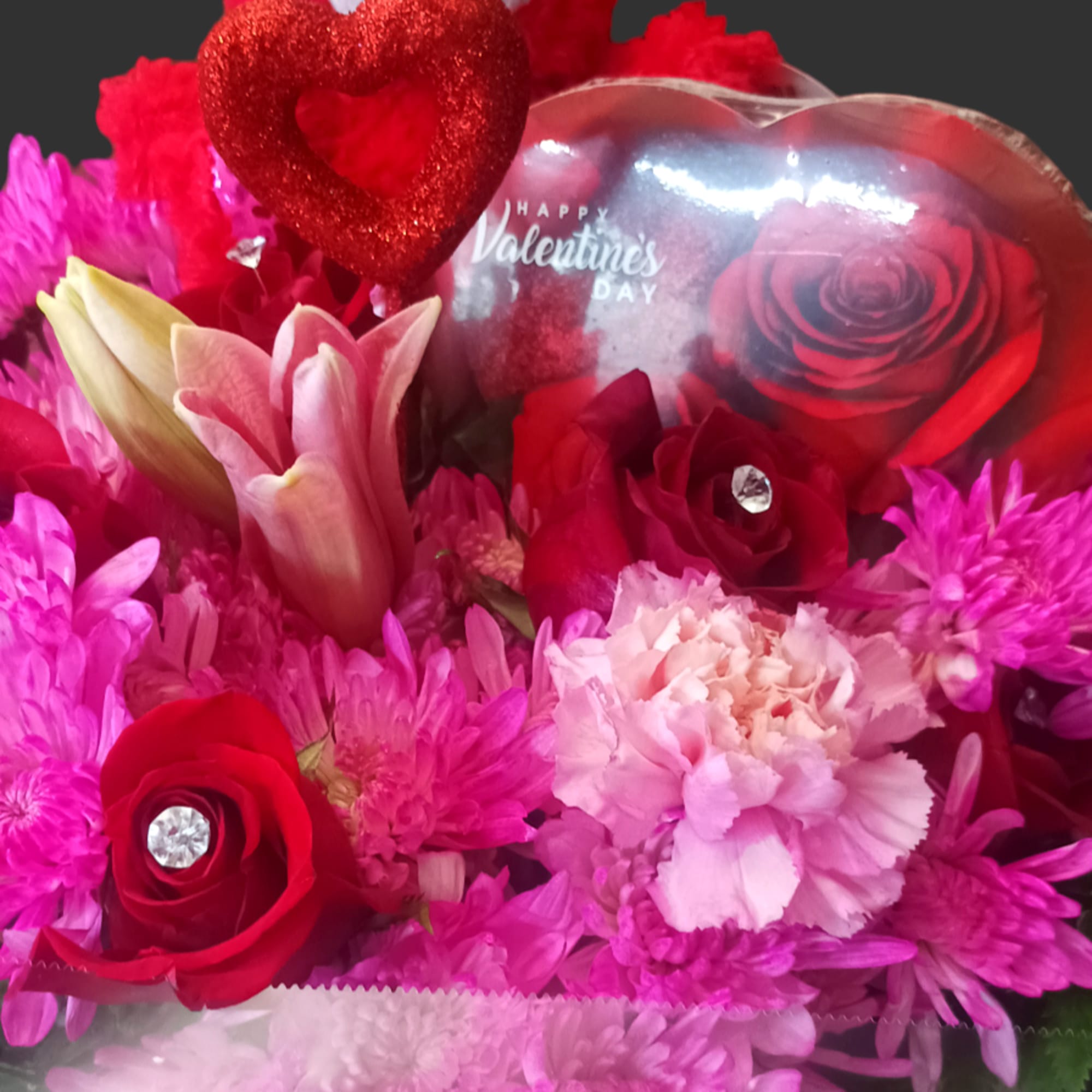 Valentine bouquet with red roses, pink flowers, and a teddy bear