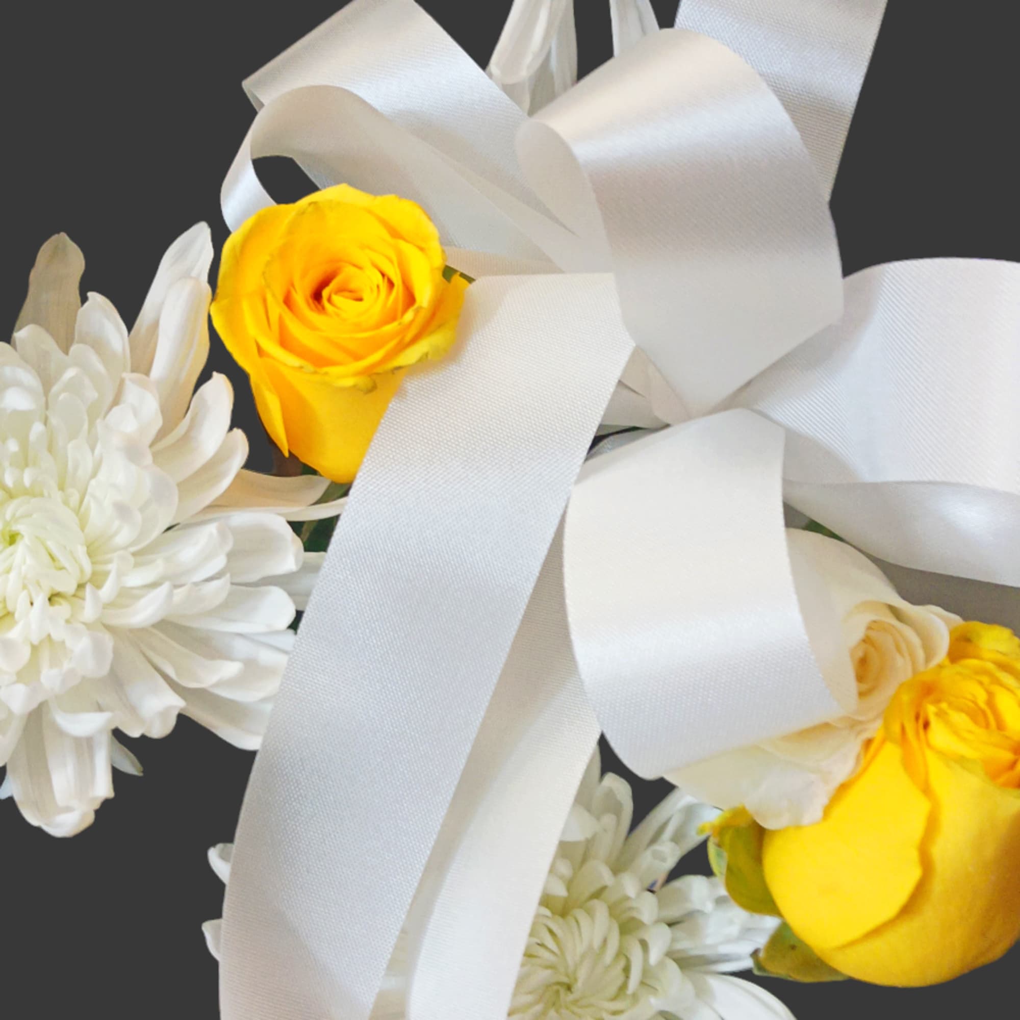 White chrysanthemums and yellow roses tied with a white ribbon
