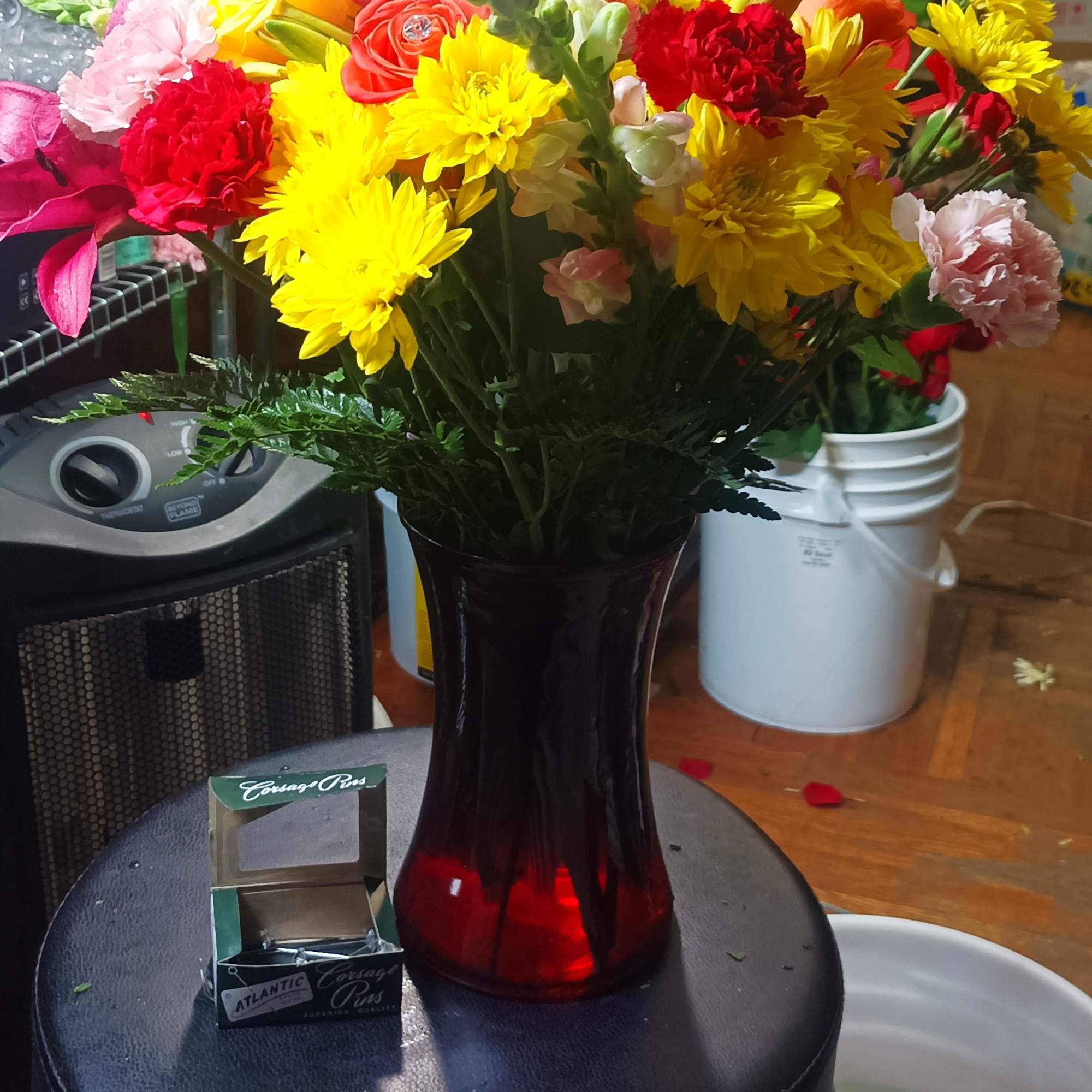 Colorful mixed bouquet in a red glass vase with yellow and pink blooms