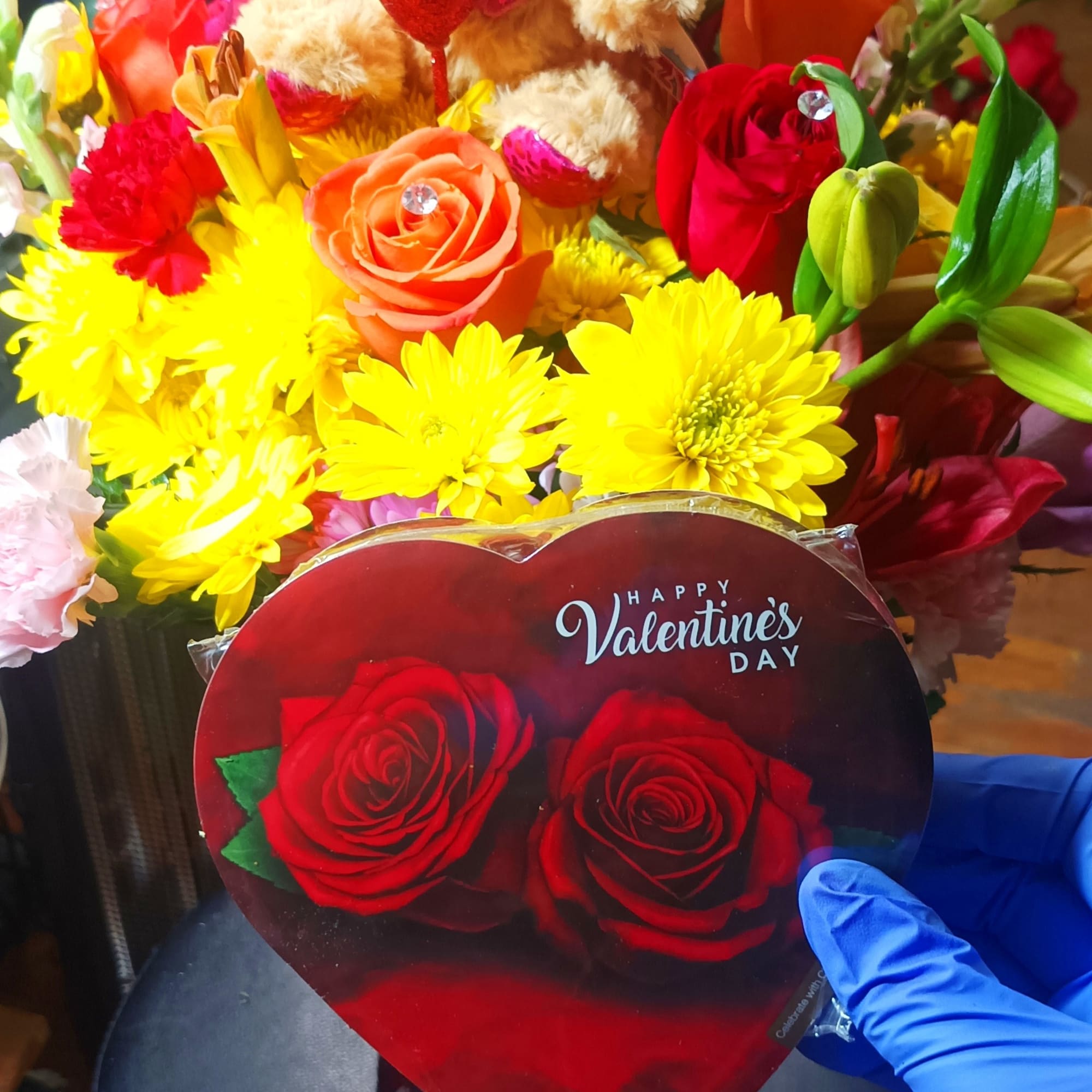 Bouquet with a teddy bear, roses, and bright mixed flowers
