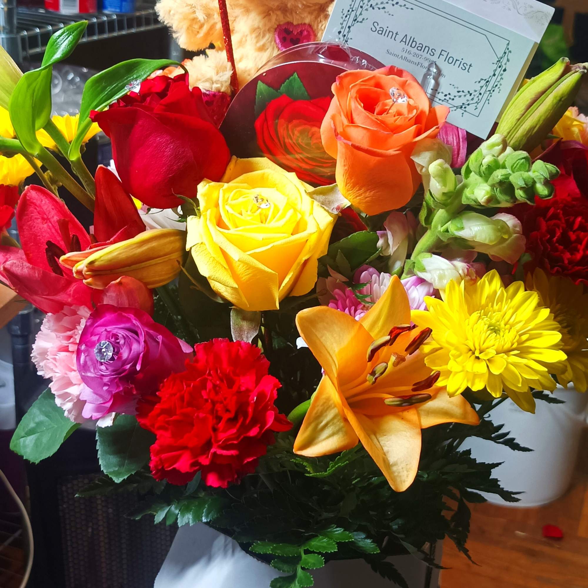 Mixed bouquet with a teddy bear and heart pick in a box