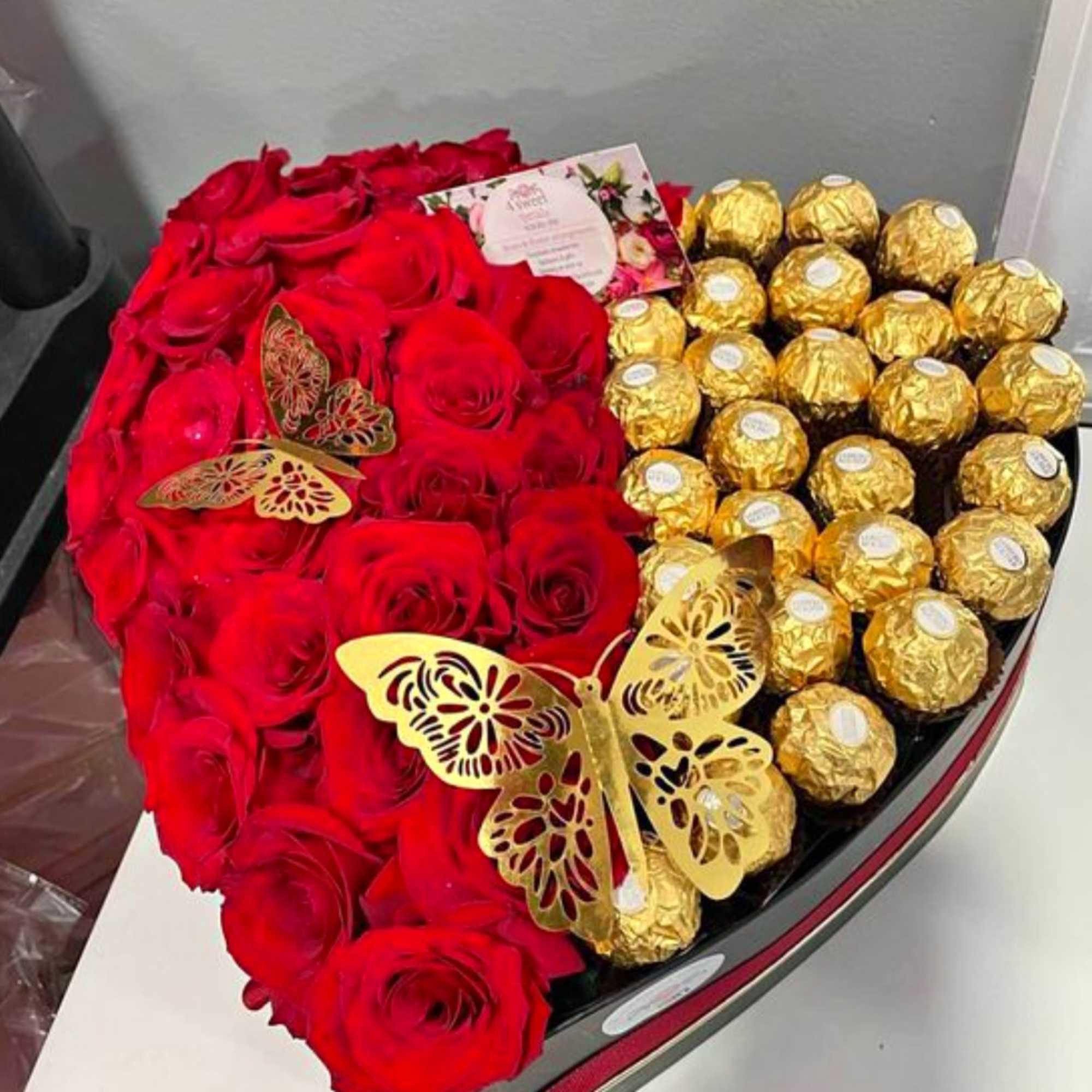 Heart-shaped box of red roses and gold-wrapped chocolates
