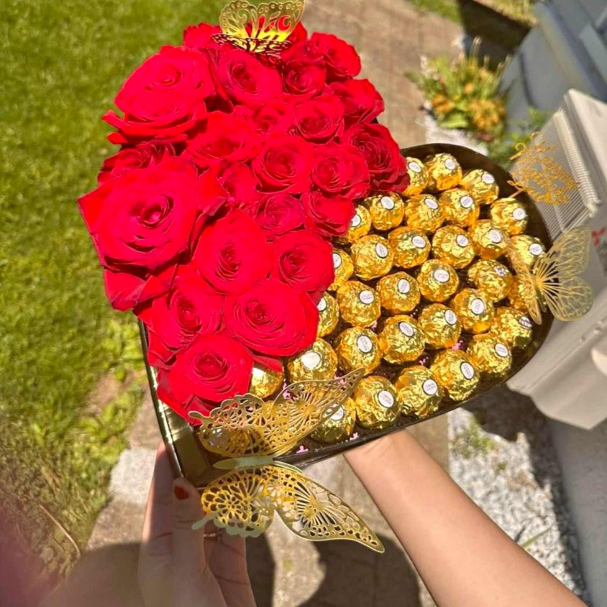 Heart-shaped box with red roses and gold-wrapped chocolates