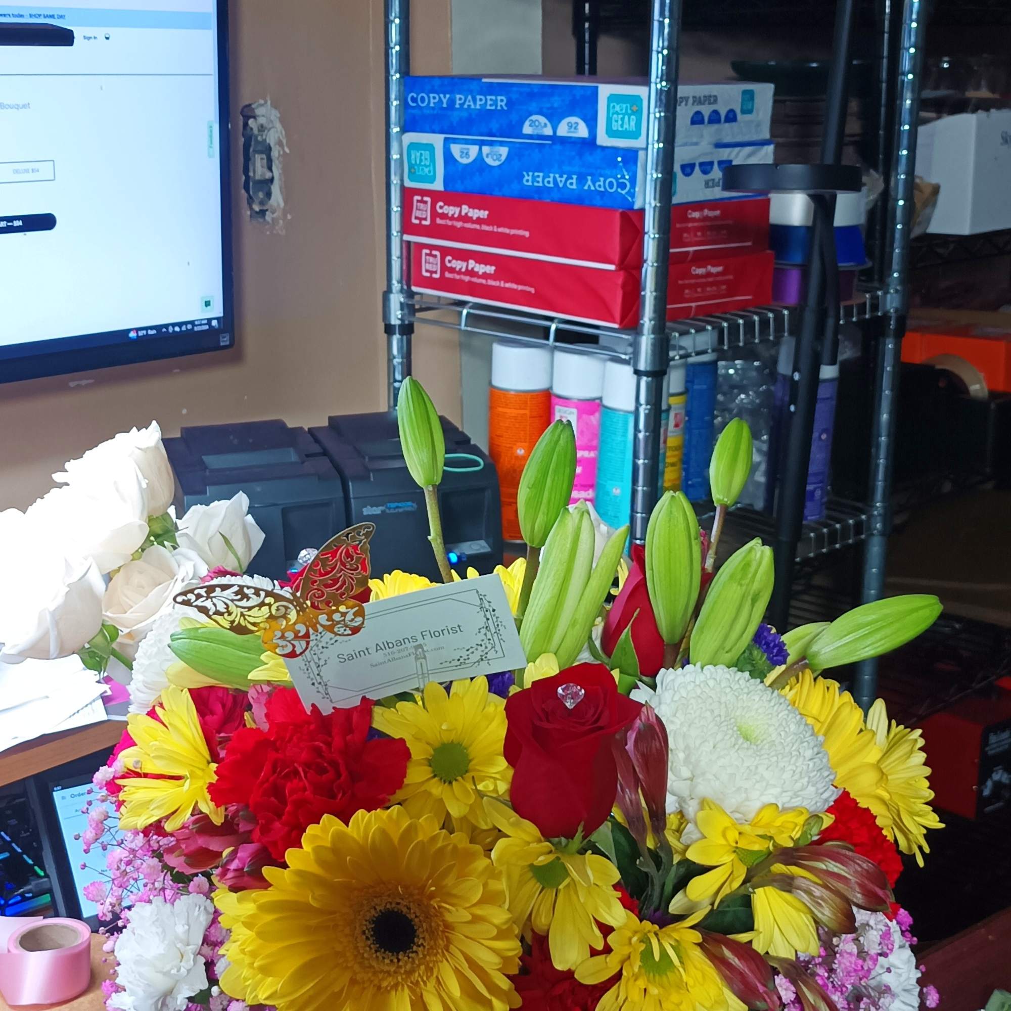 Mixed bouquet of yellow, red, and white flowers in a glass vase
