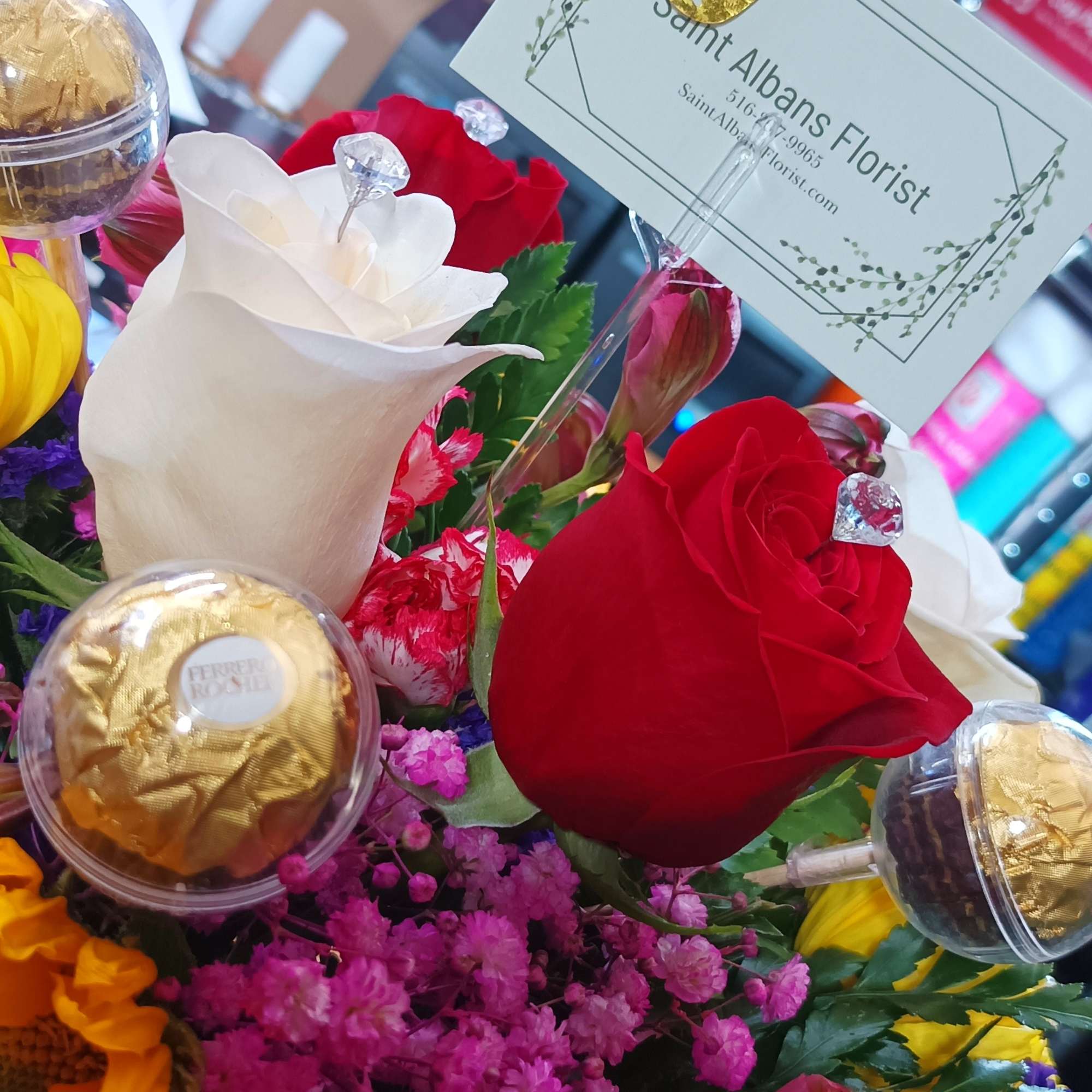Bouquet of red and white roses with a gold butterfly topper and chocolates