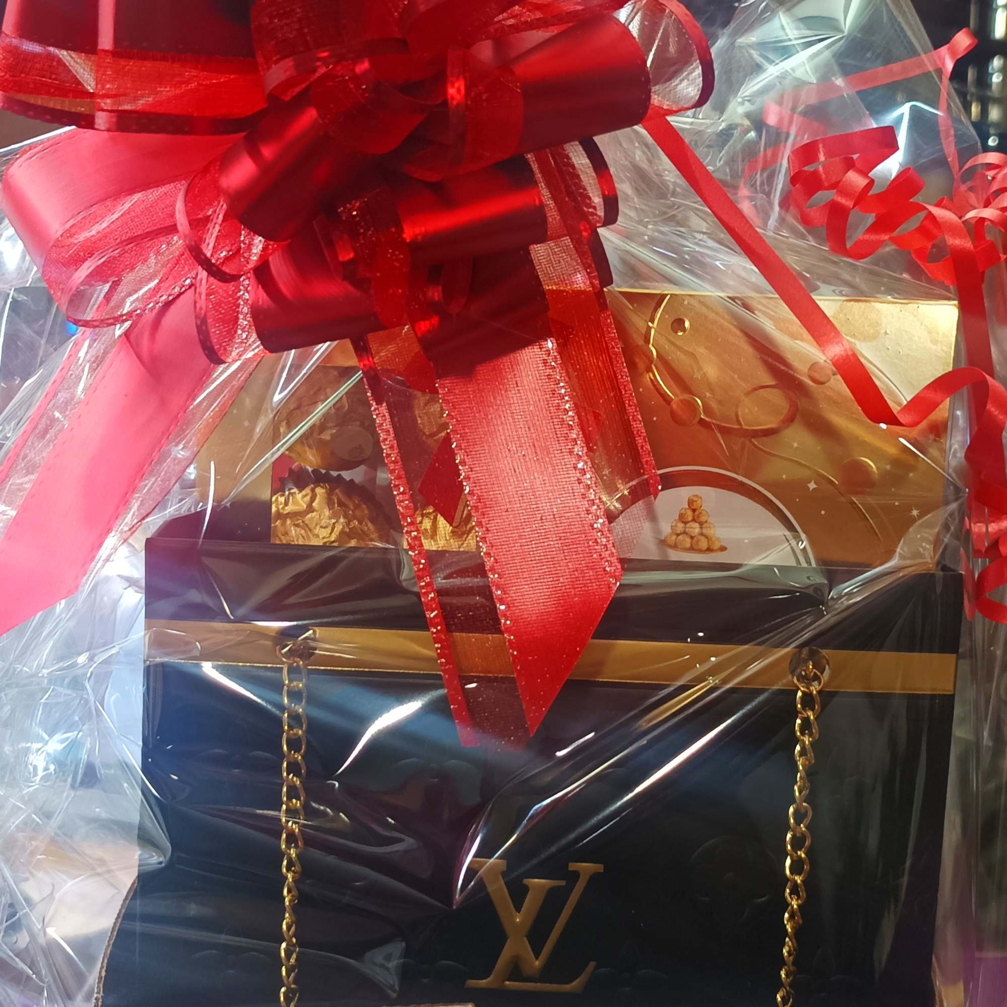 Gift basket wrapped in clear cellophane with a large red bow, photo 3 of 6