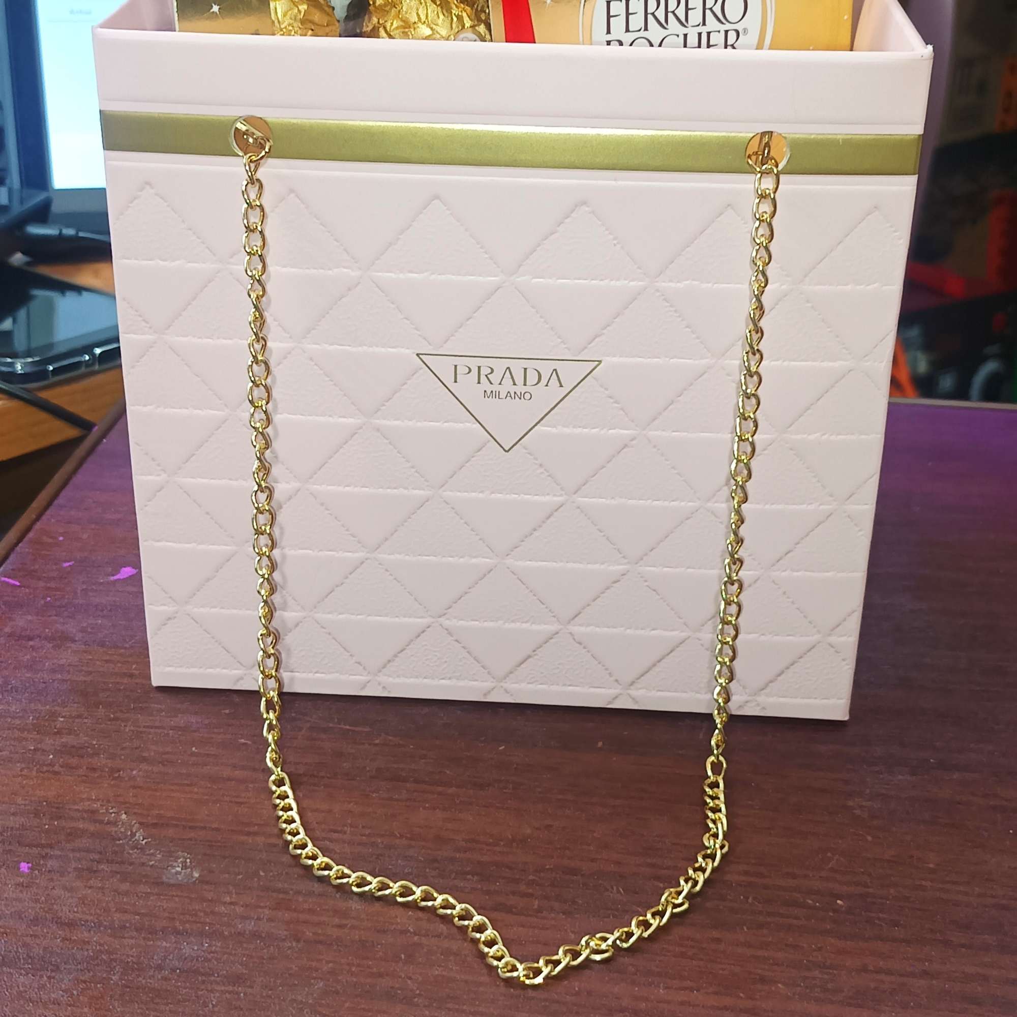 Ferrero Rocher chocolates in a Prada gift bag with a red bow