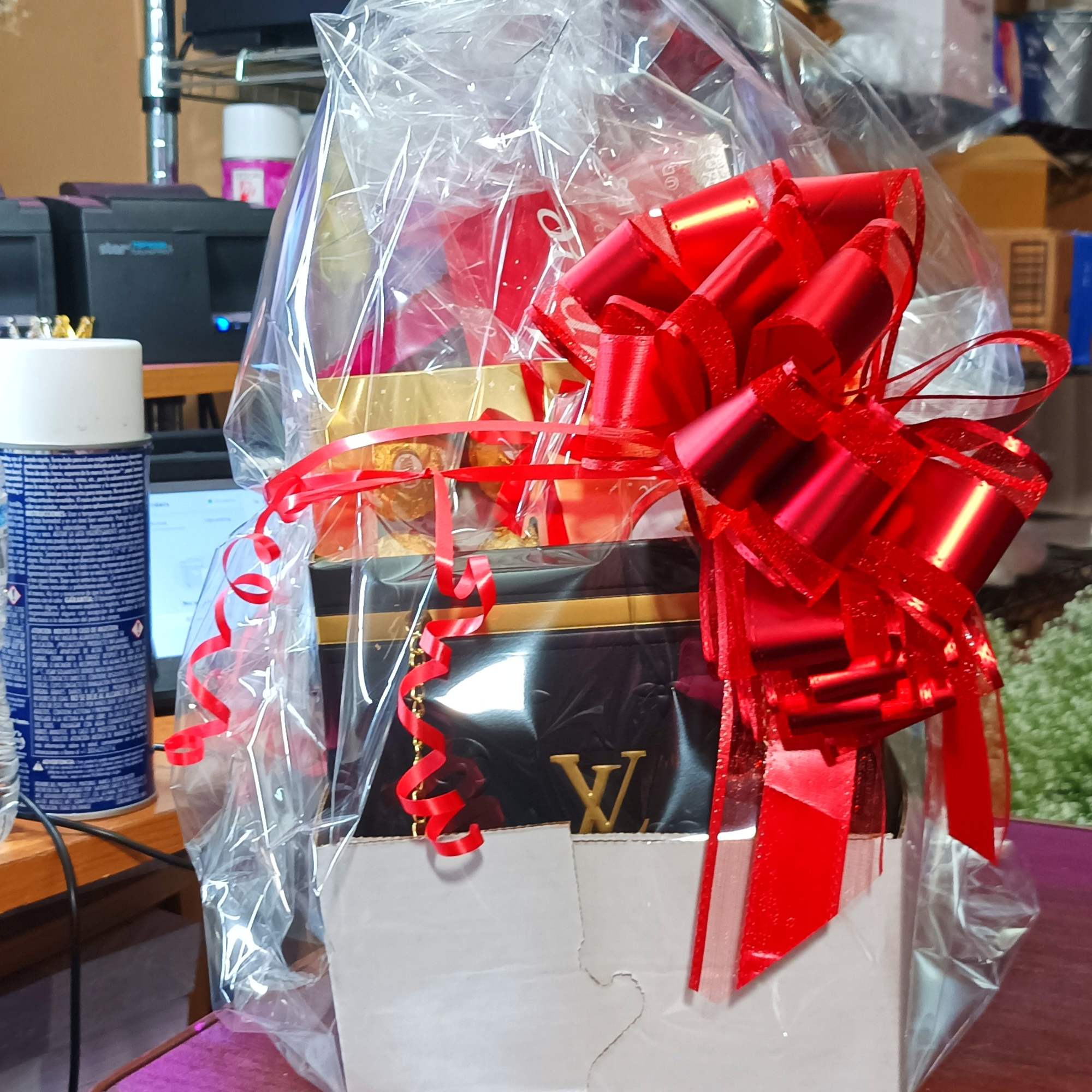 Gift basket wrapped in clear cellophane with a large red bow, photo 4 of 6