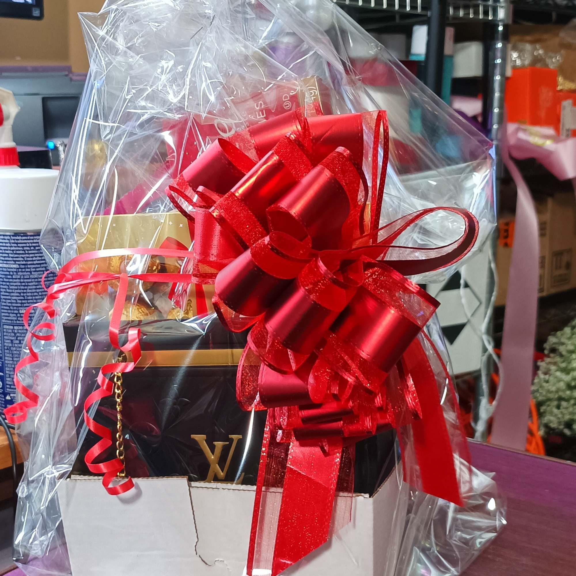 Gift basket wrapped in clear cellophane with a large red bow, photo 6 of 6