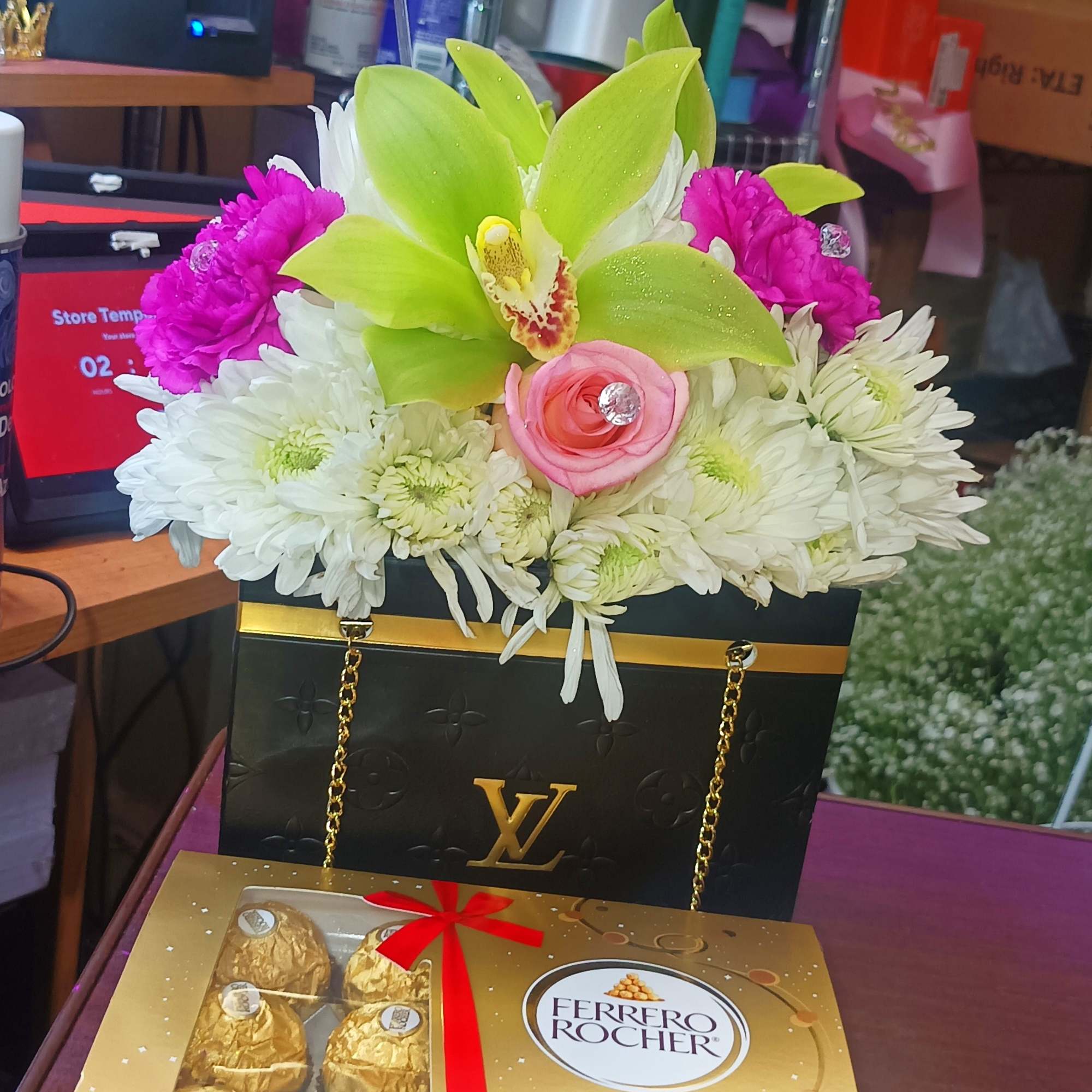 Flower arrangement in a black gift bag with Ferrero Rocher boxes below, photo 5 of 5