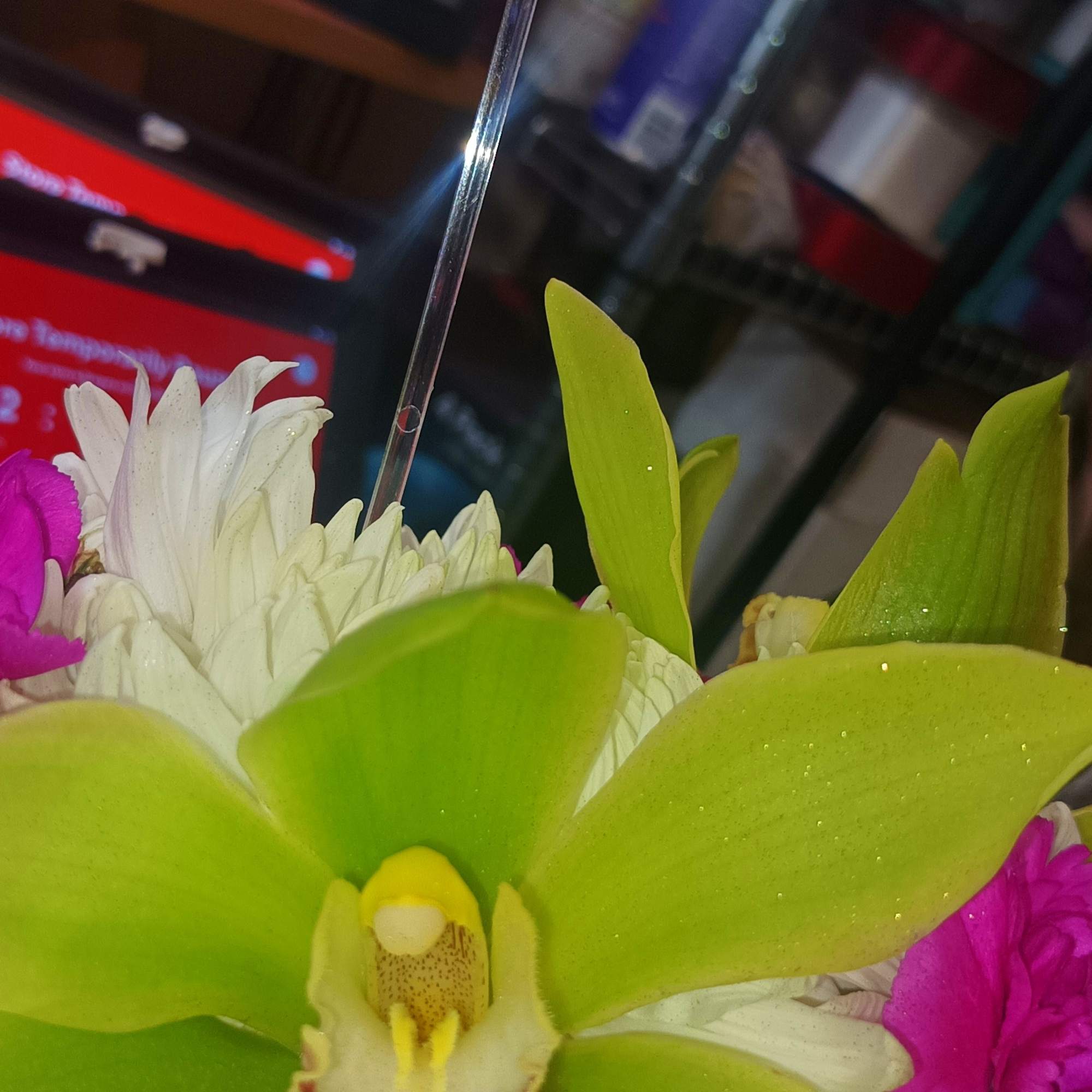 Pink rose and green orchid in a mixed bouquet with white flowers