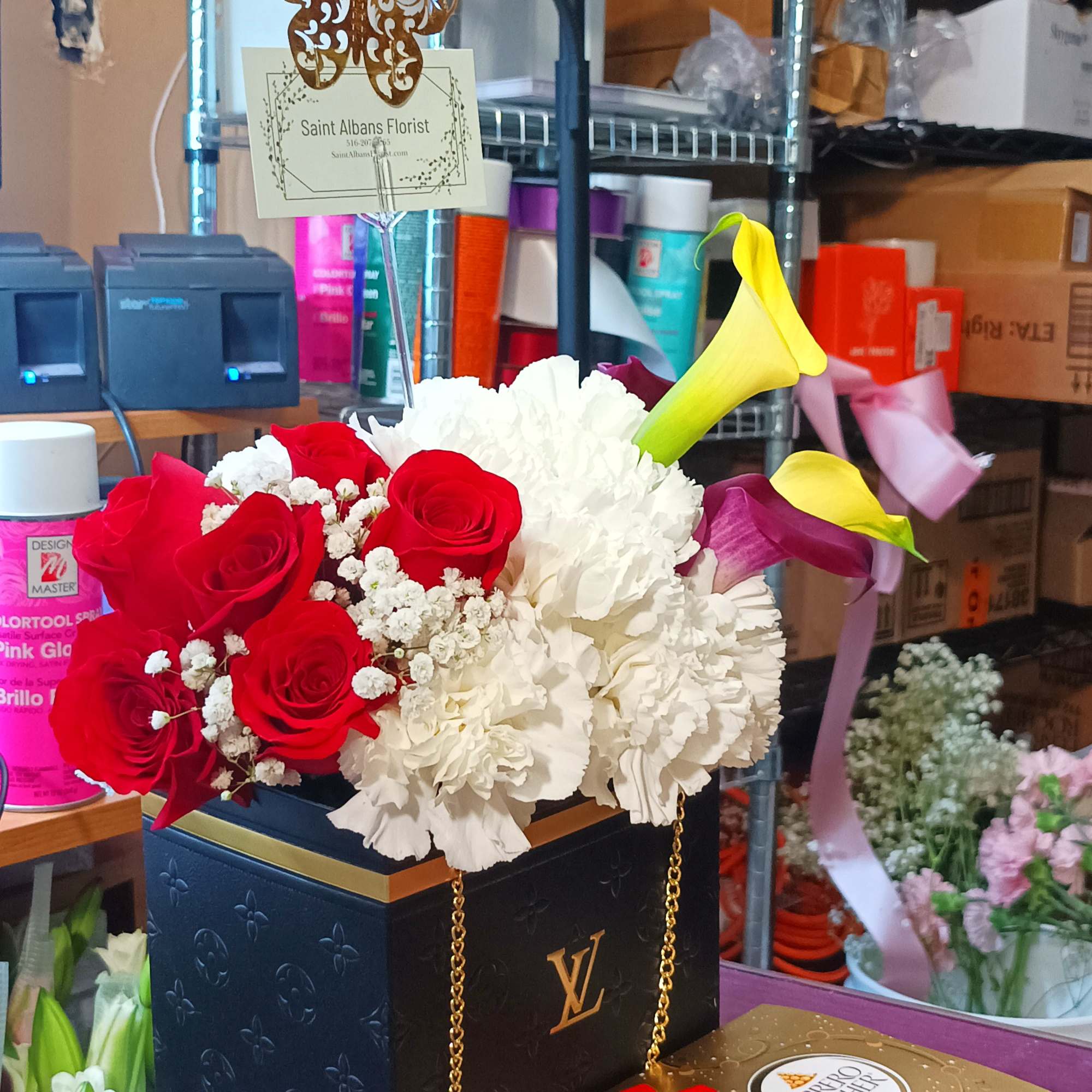 Red roses and white carnations in a black box with chocolates