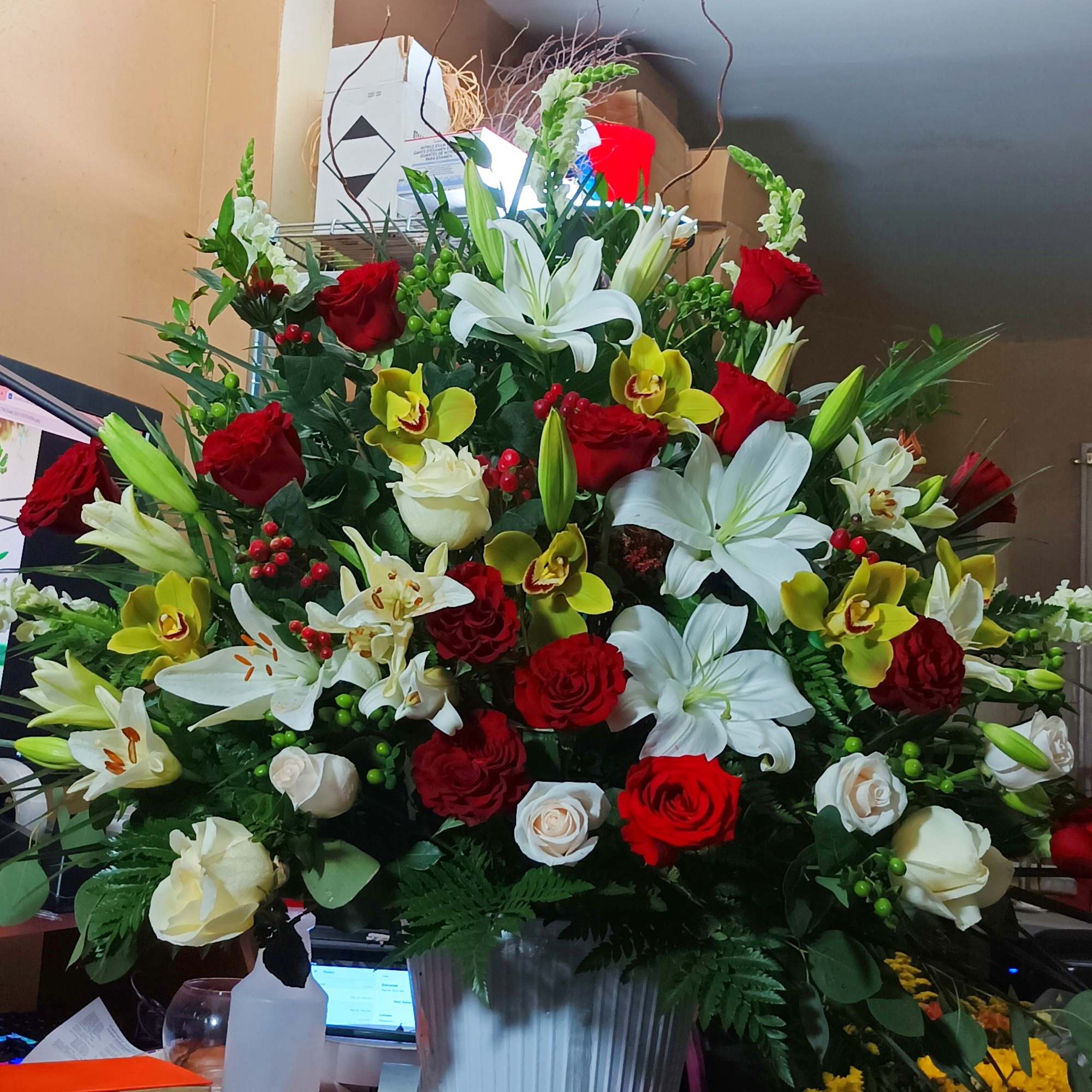 Large mixed bouquet in a metal vase with red and white flowers