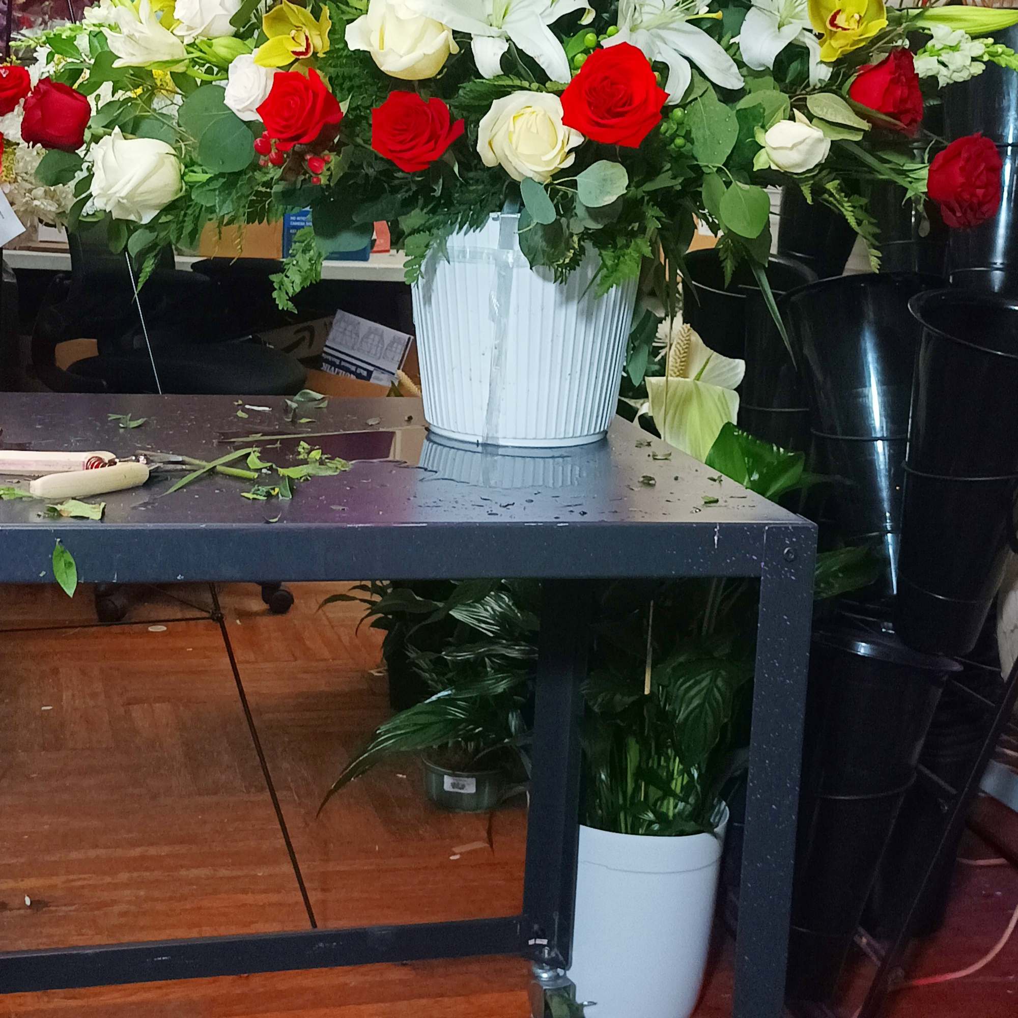 Large bouquet of red and white roses with lilies in a white vase