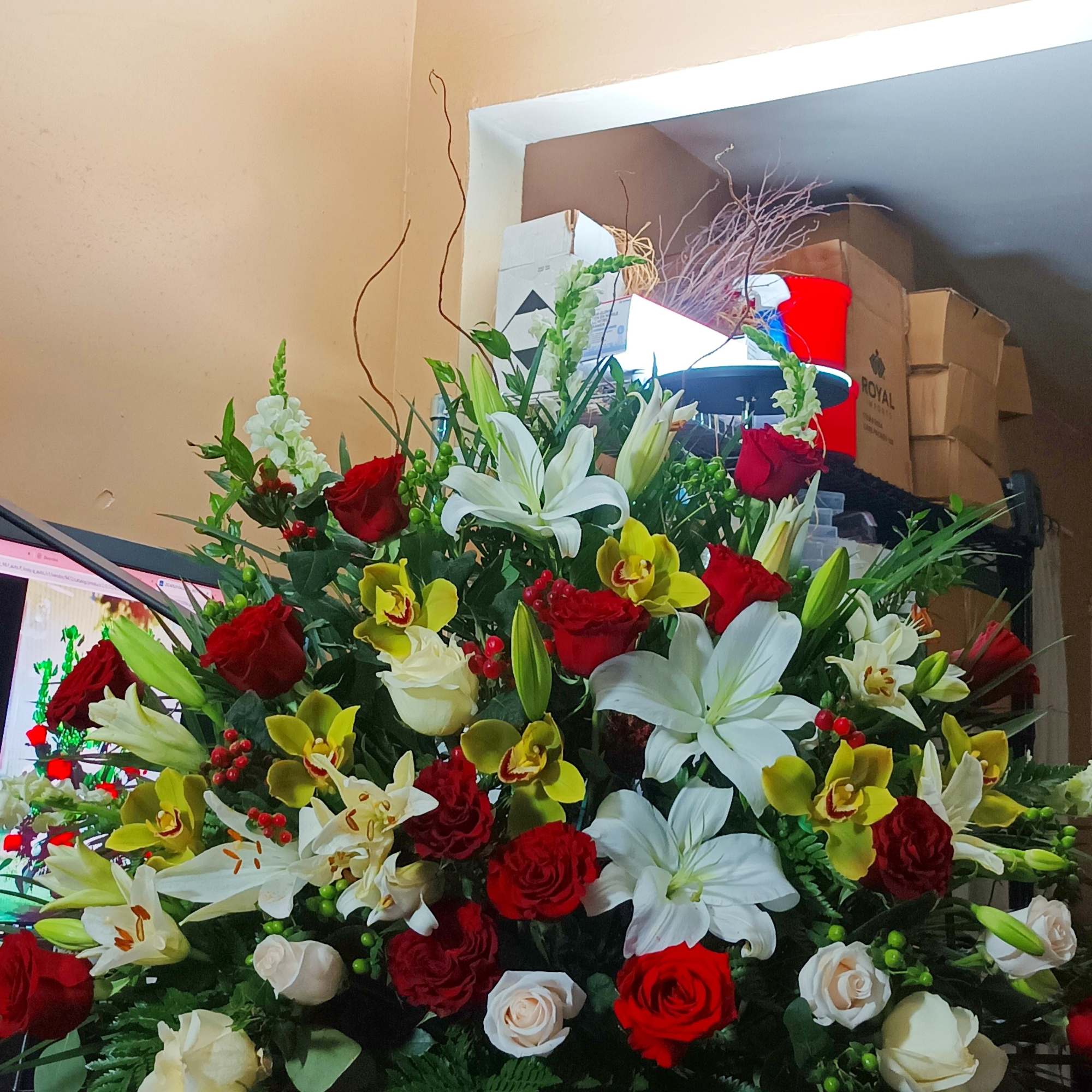 Large mixed flower arrangement in a white vase with red, white, and yellow blooms, photo 8 of 8