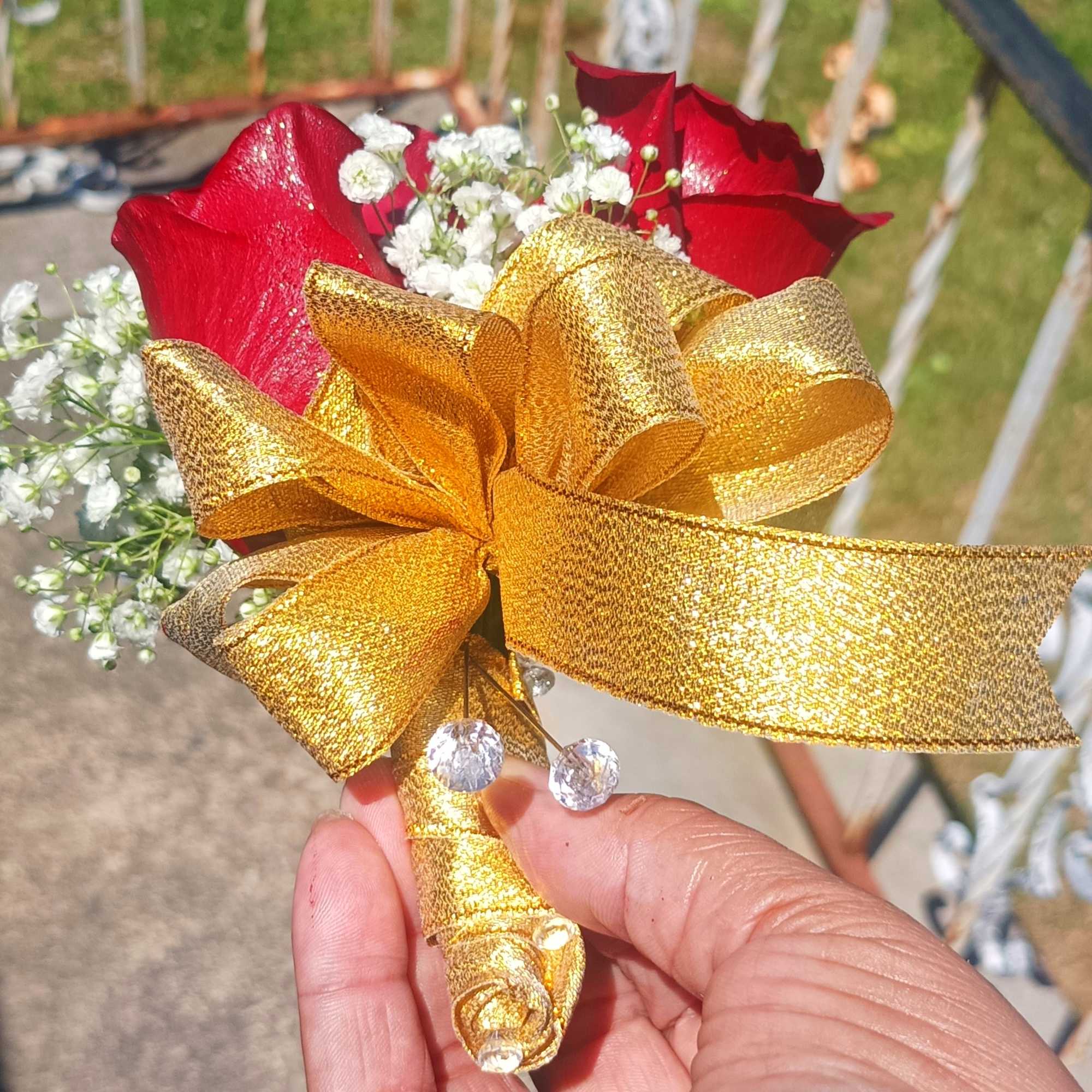 Small bouquet of red roses with baby's breath and a gold ribbon
