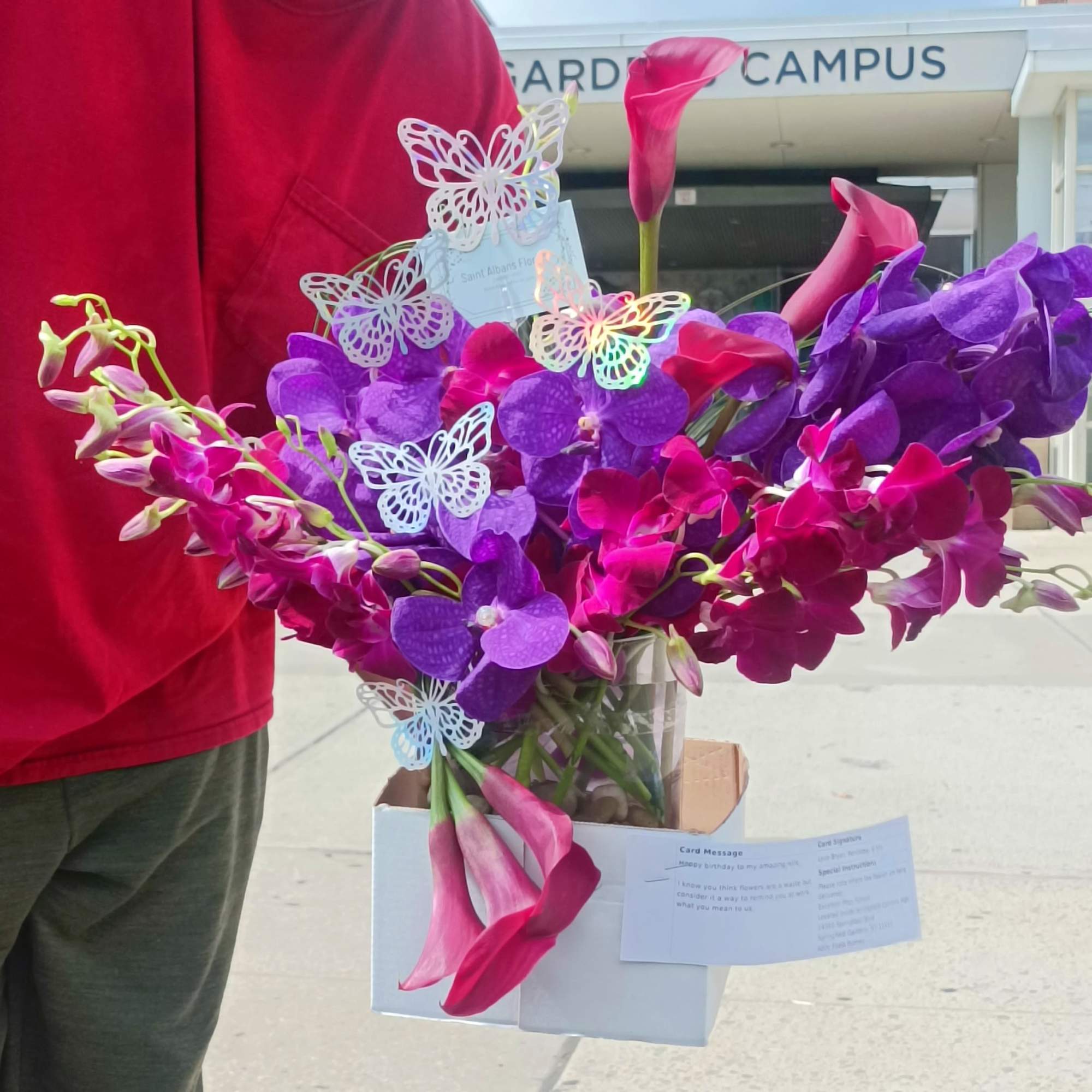Bouquet of purple orchids and pink calla lilies in a white box