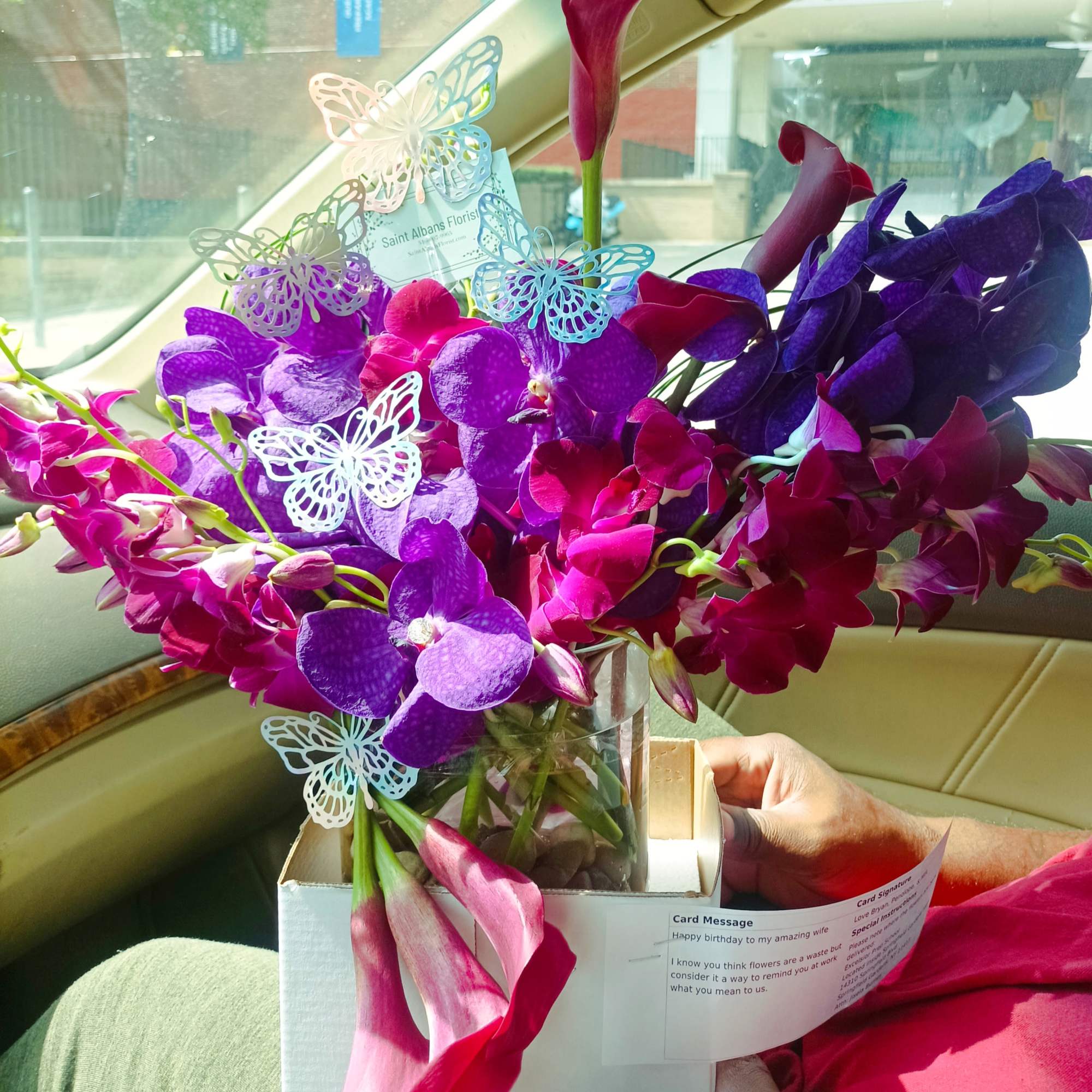 Bouquet of purple orchids and pink calla lilies in a glass vase