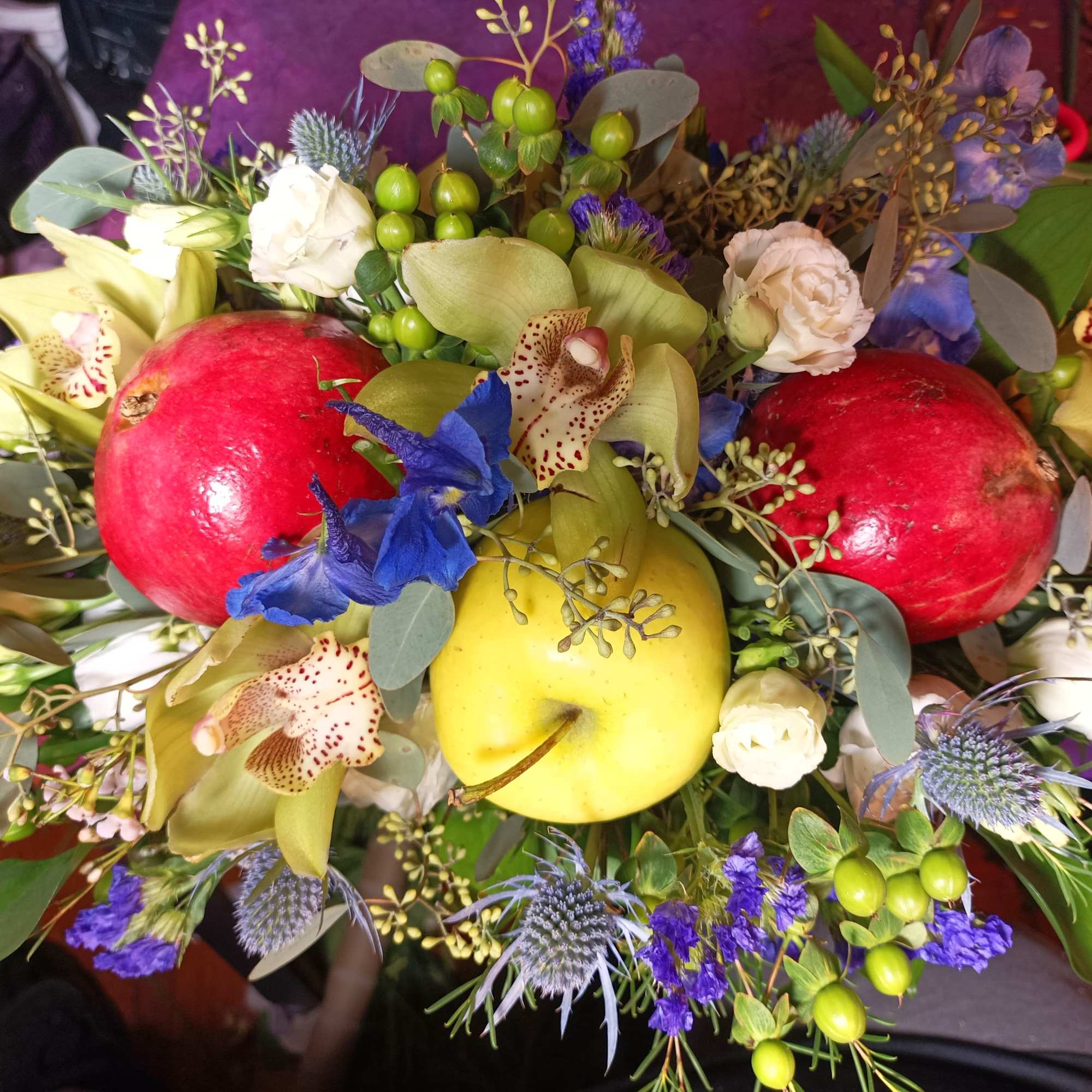 Bouquet with pomegranates, orchids, and blue thistles