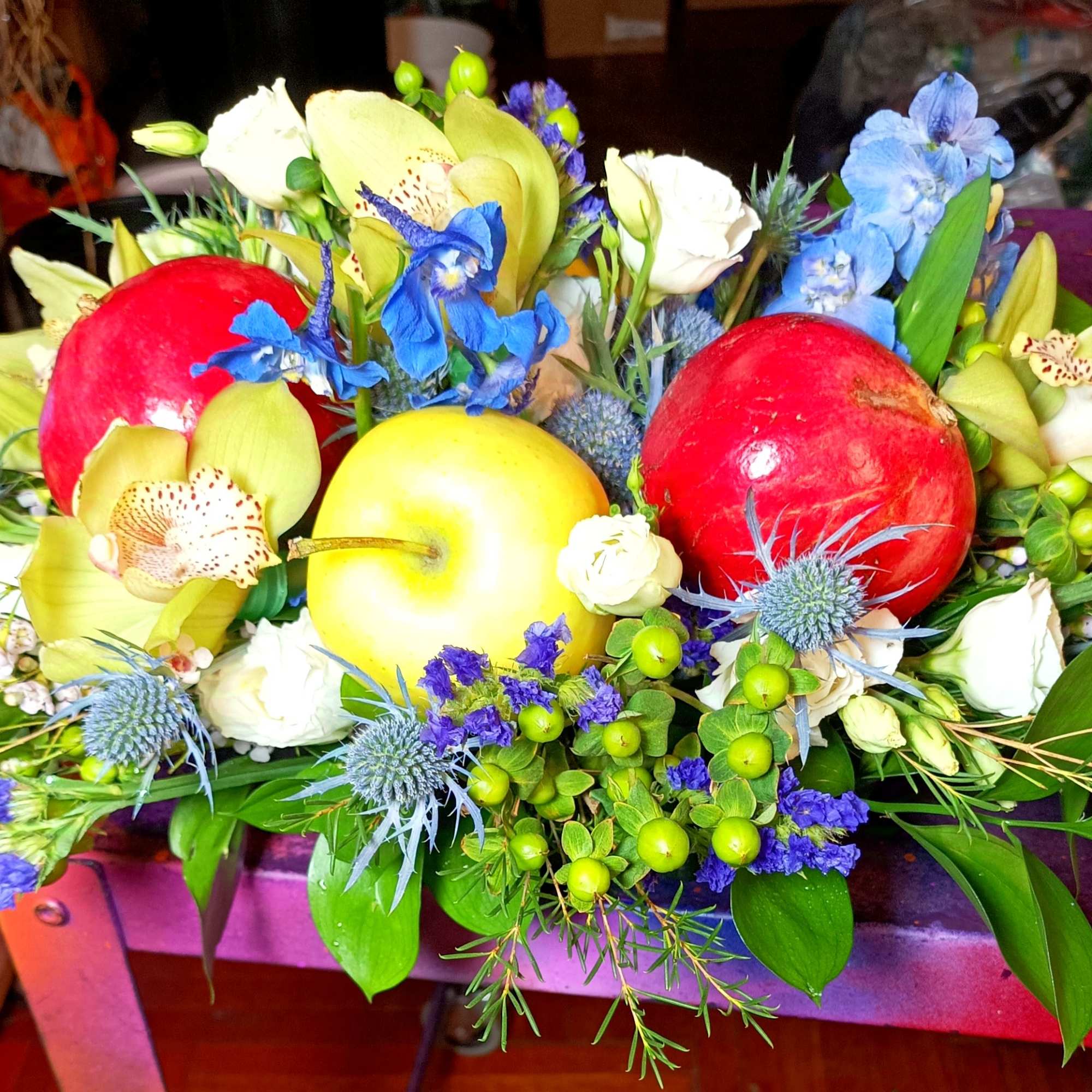 Bouquet with apples and blue, white, and yellow flowers