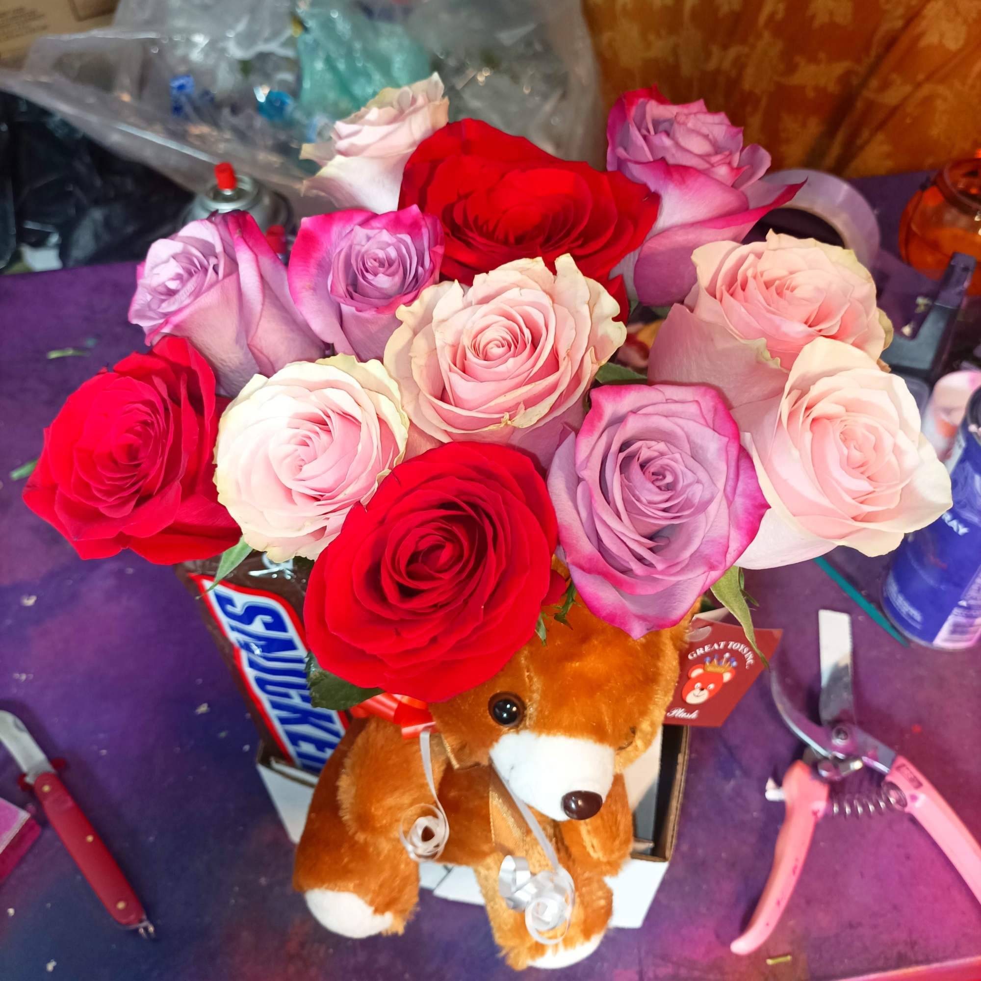 Bouquet of multicolored roses with a teddy bear