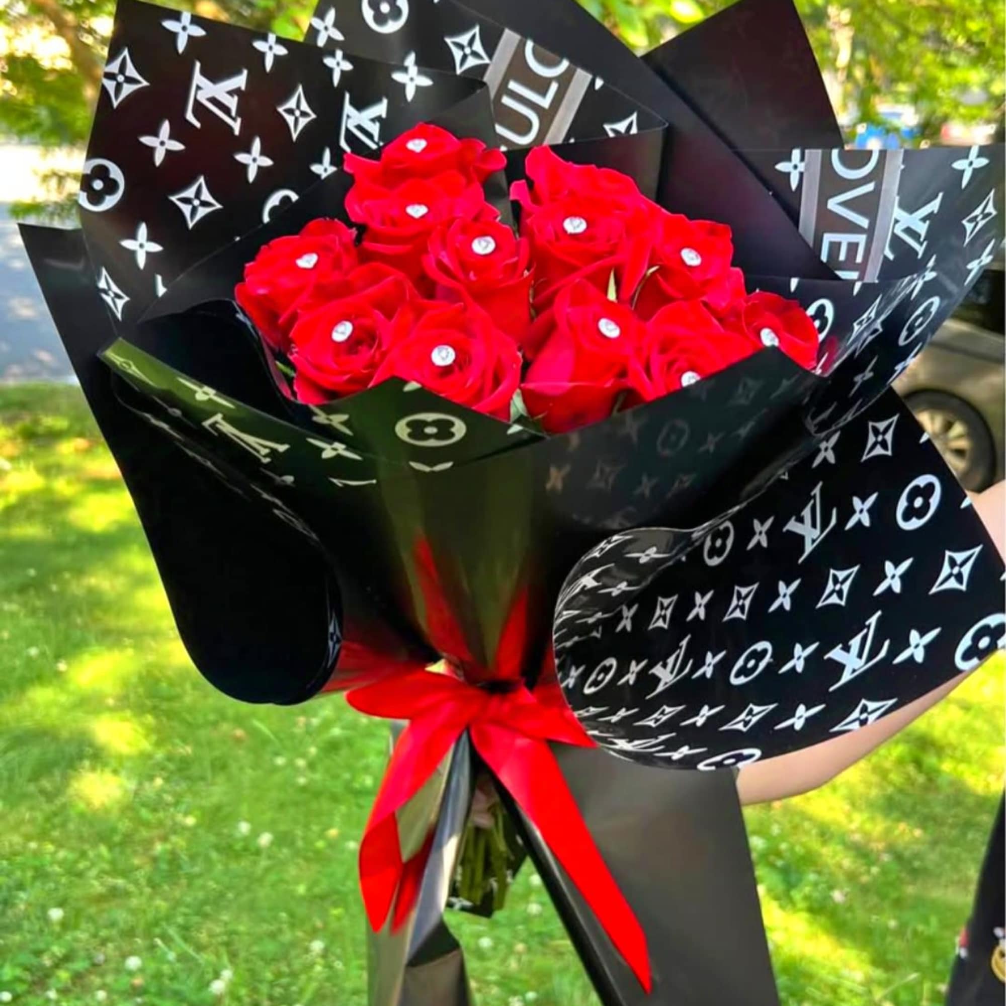 Bouquet of red roses wrapped in black patterned paper with a red ribbon, photo 4 of 4