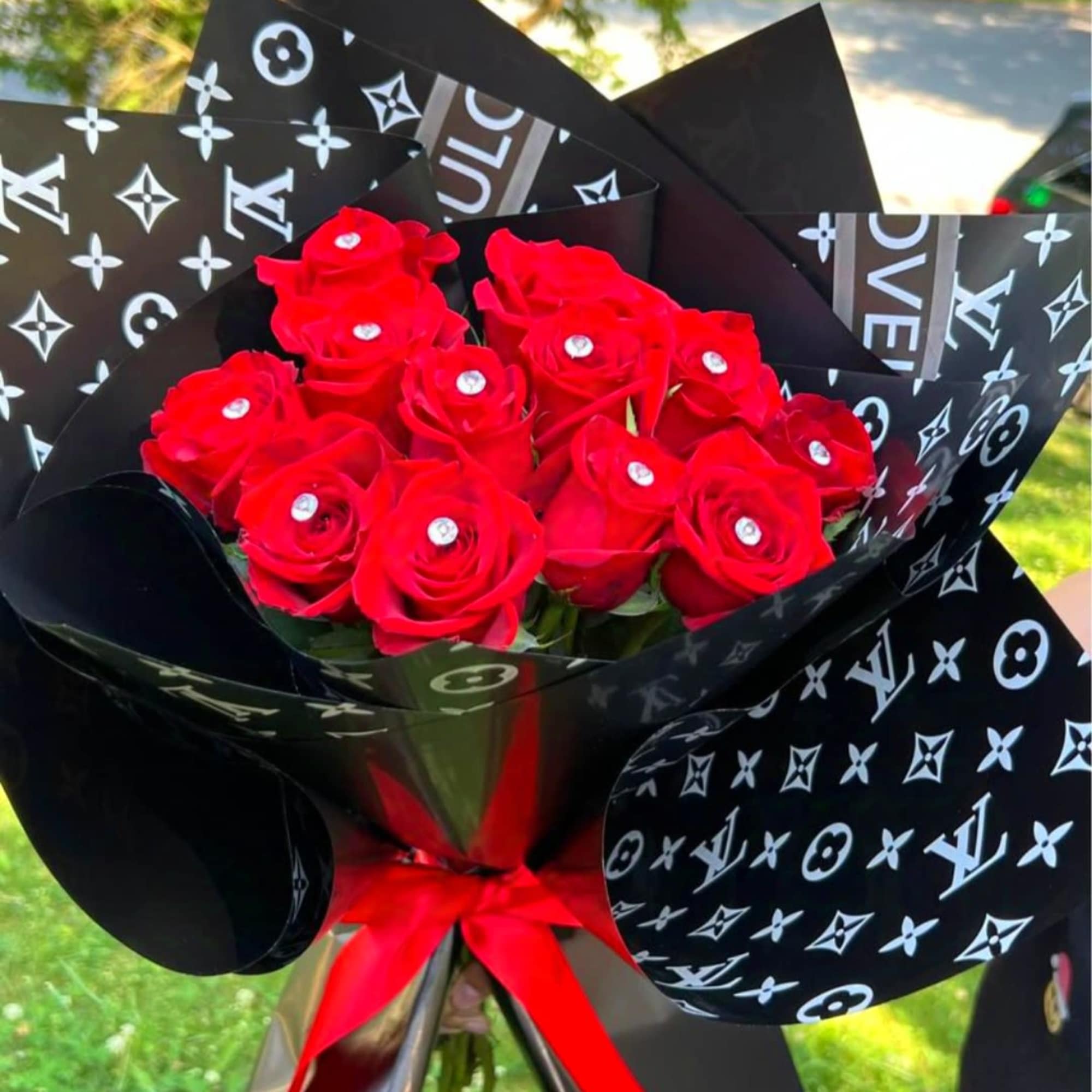 Bouquet of red roses wrapped in black patterned paper with a red ribbon, photo 3 of 7