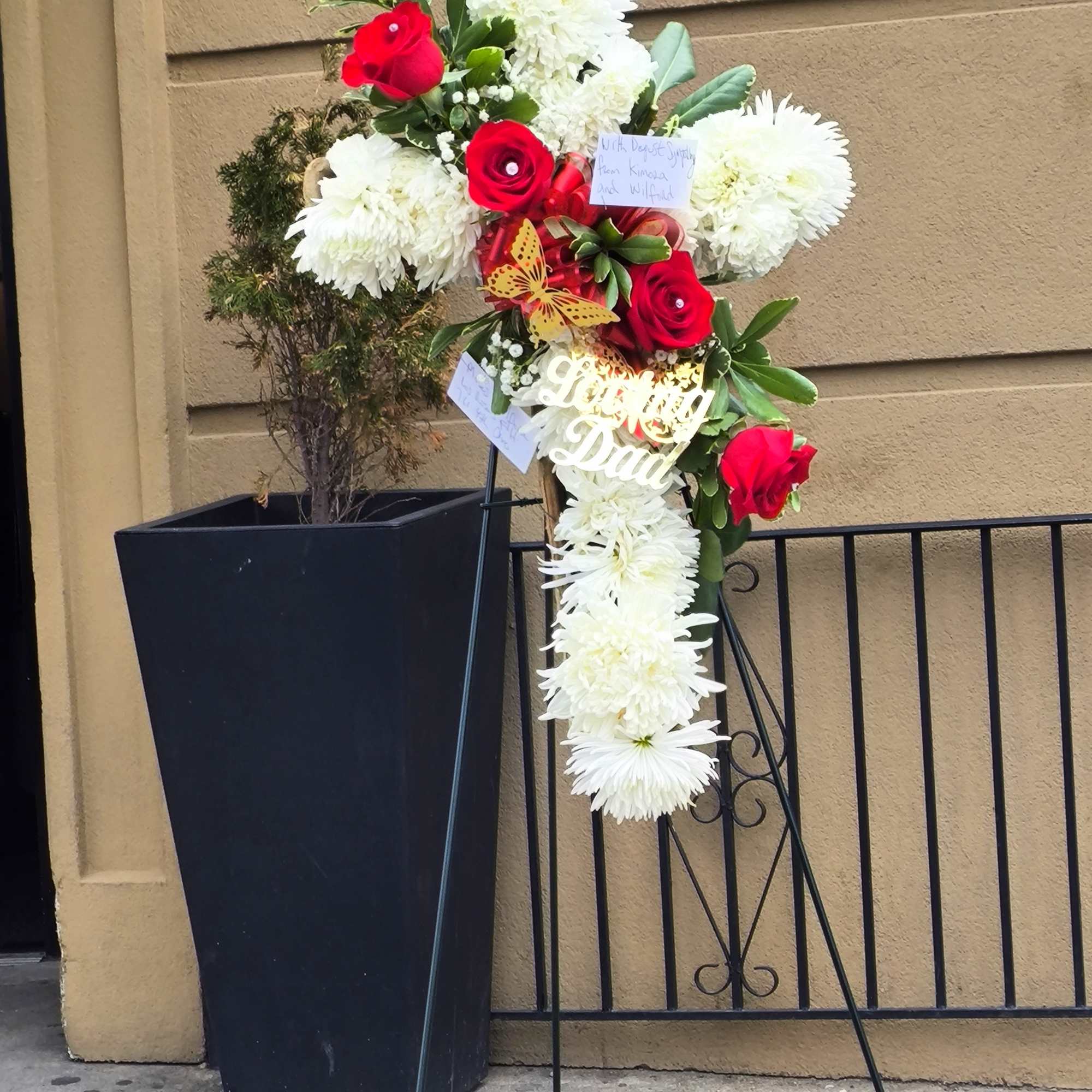 Standing floral tribute with red roses and white chrysanthemums on an easel