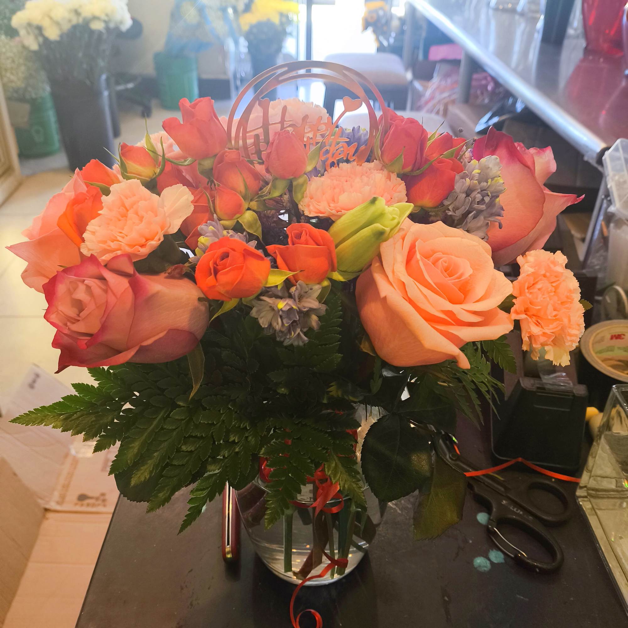 Peach and coral rose bouquet in a clear vase