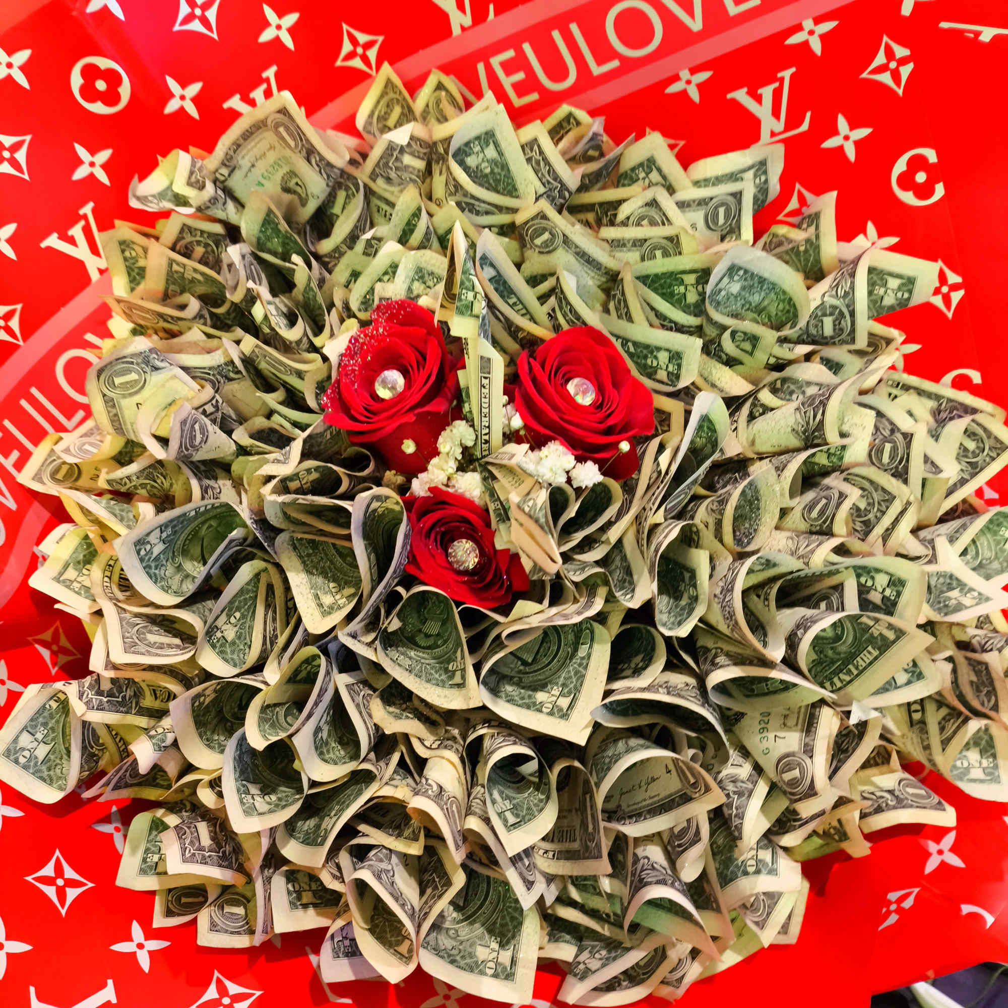 Bouquet of folded dollar bills with red roses on a red patterned background