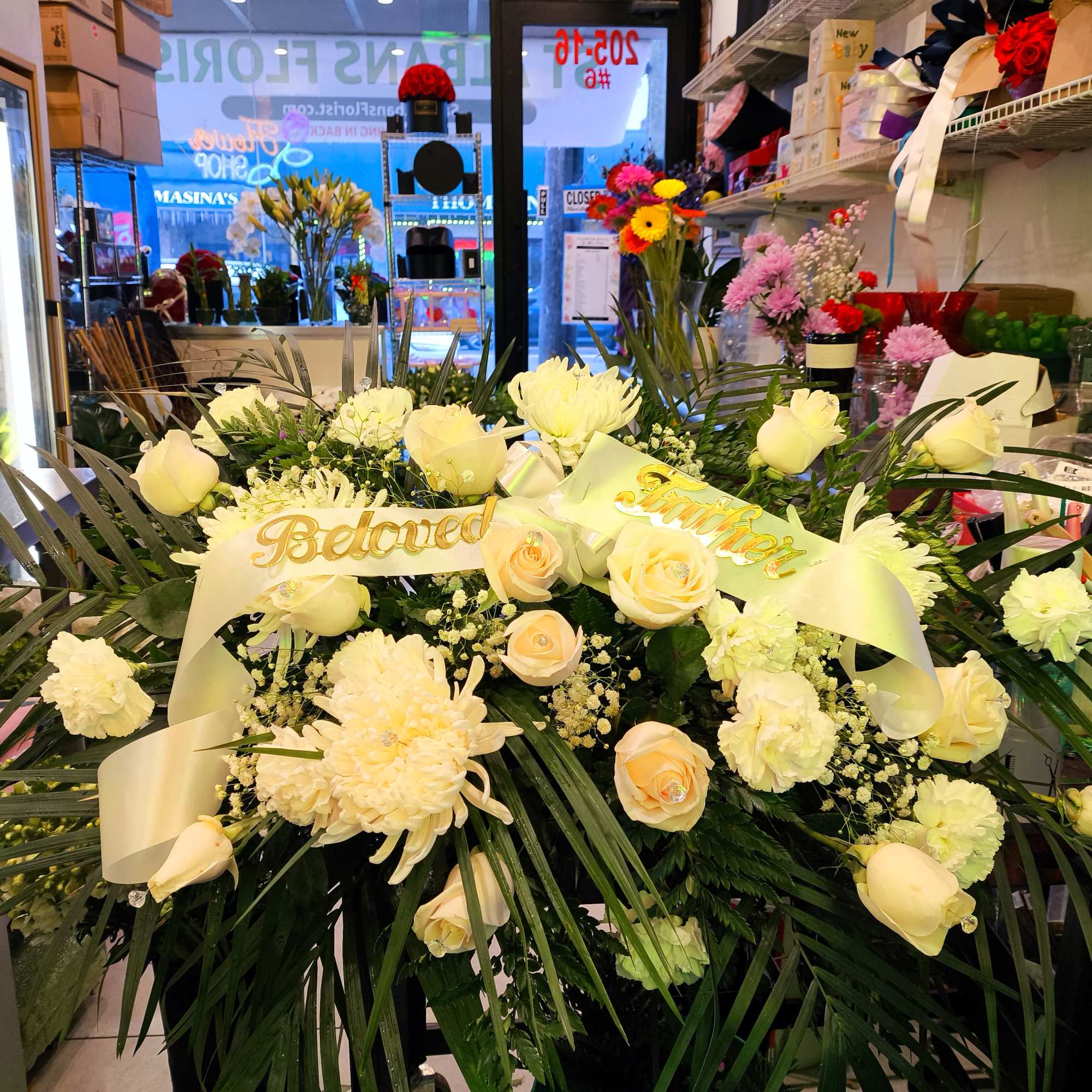 Large white floral spray with ribbon and gold lettering