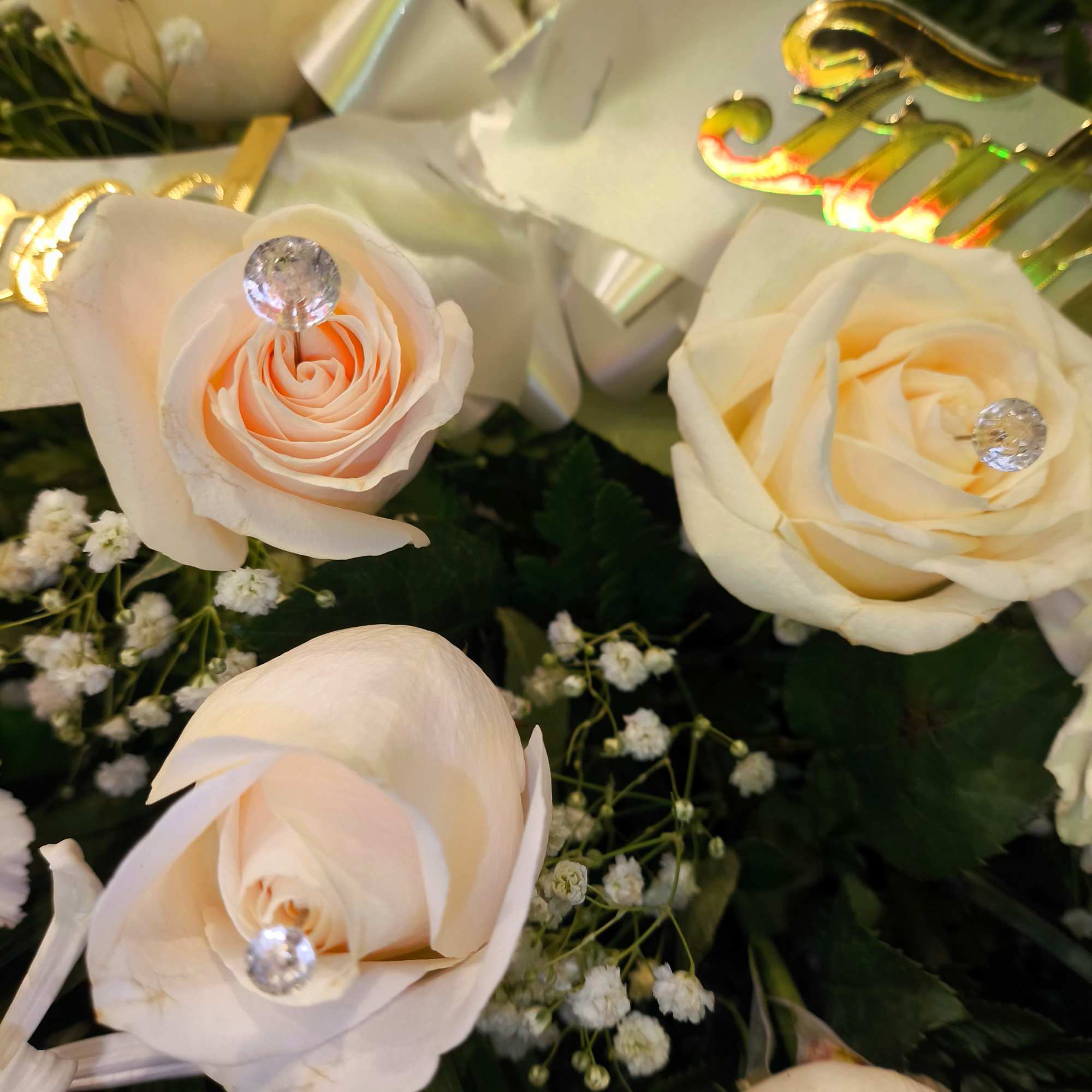 Cream roses with crystal accents and gold lettering
