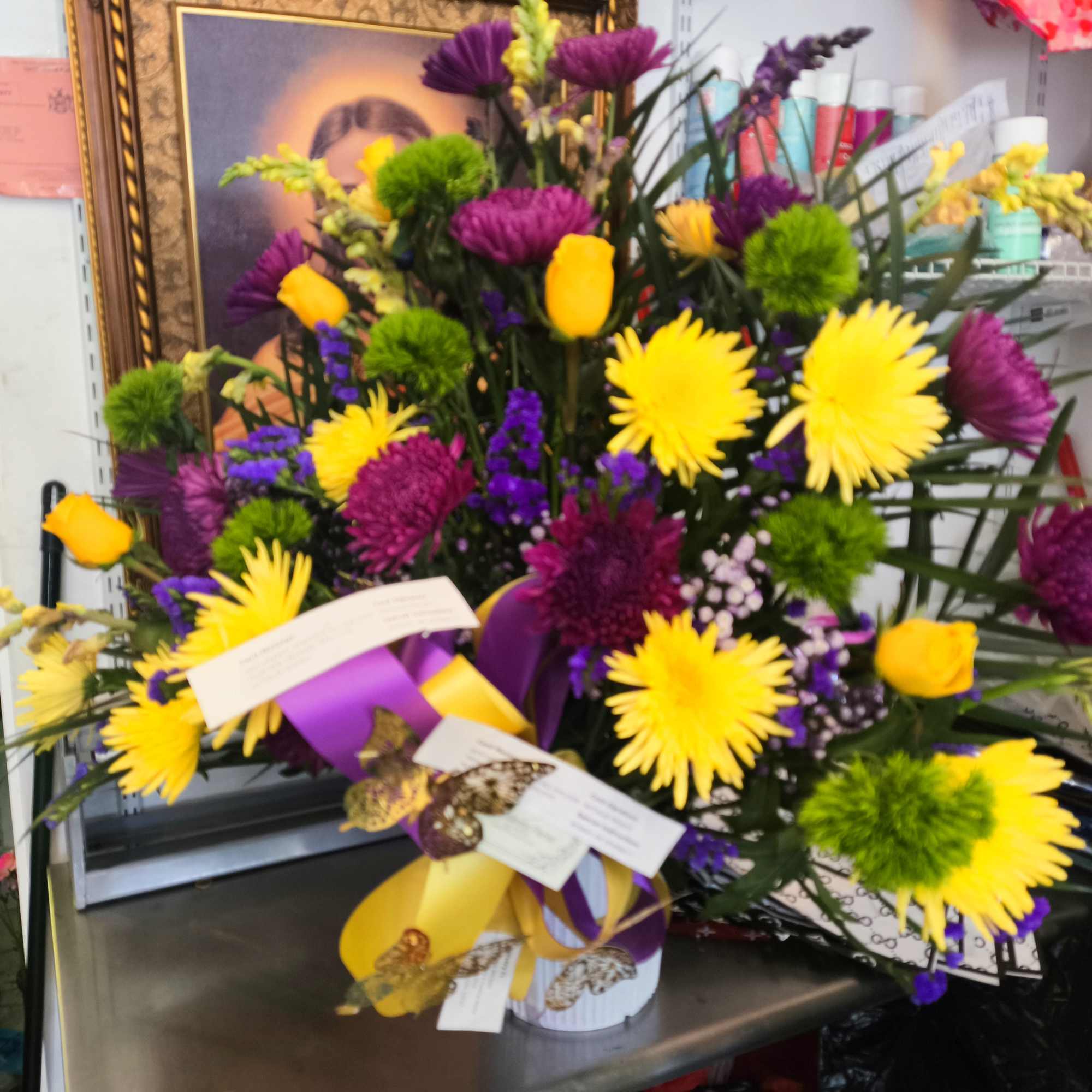 Bright mixed bouquet with yellow and purple flowers in a white container