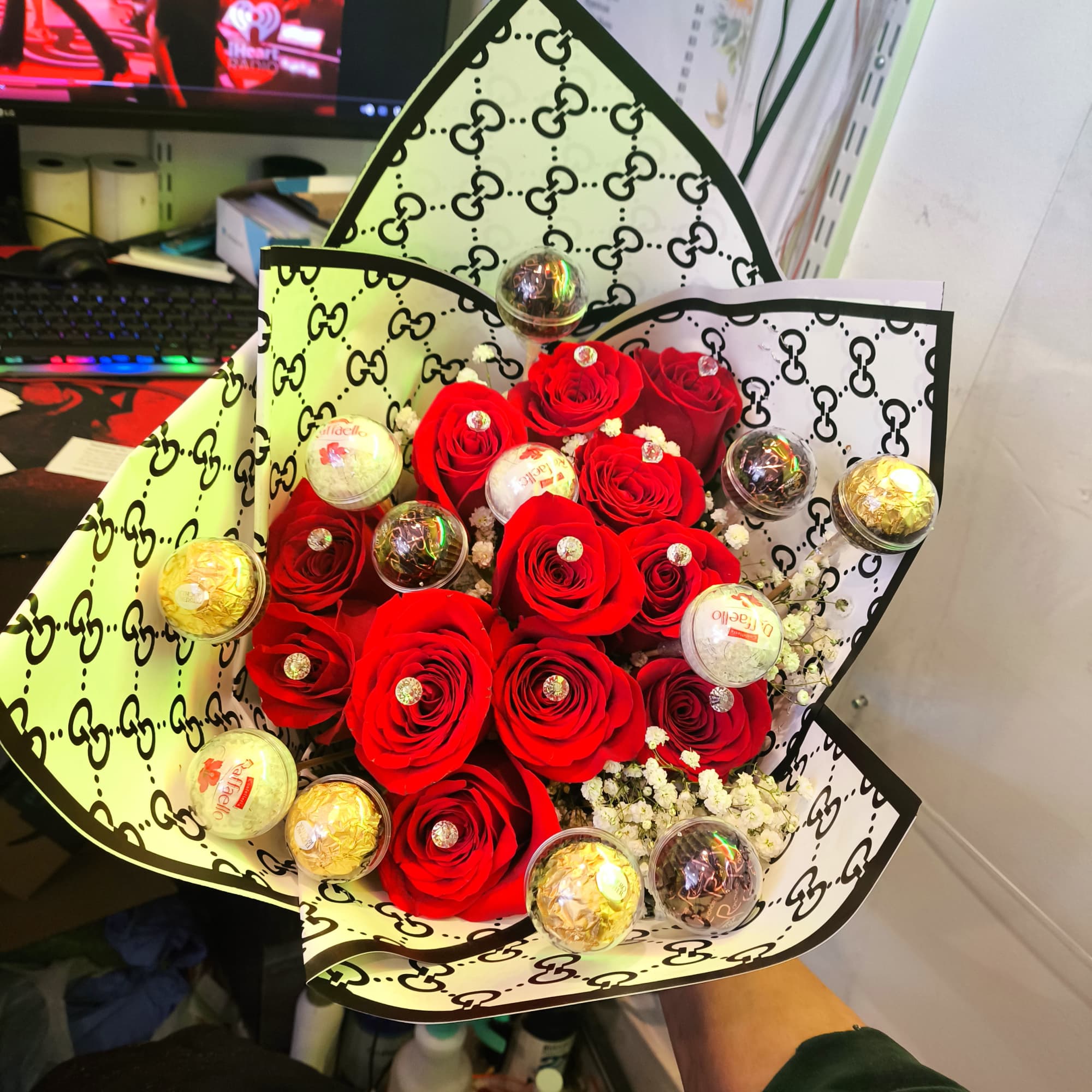 Bouquet of red roses with small white filler flowers and wrapped chocolates