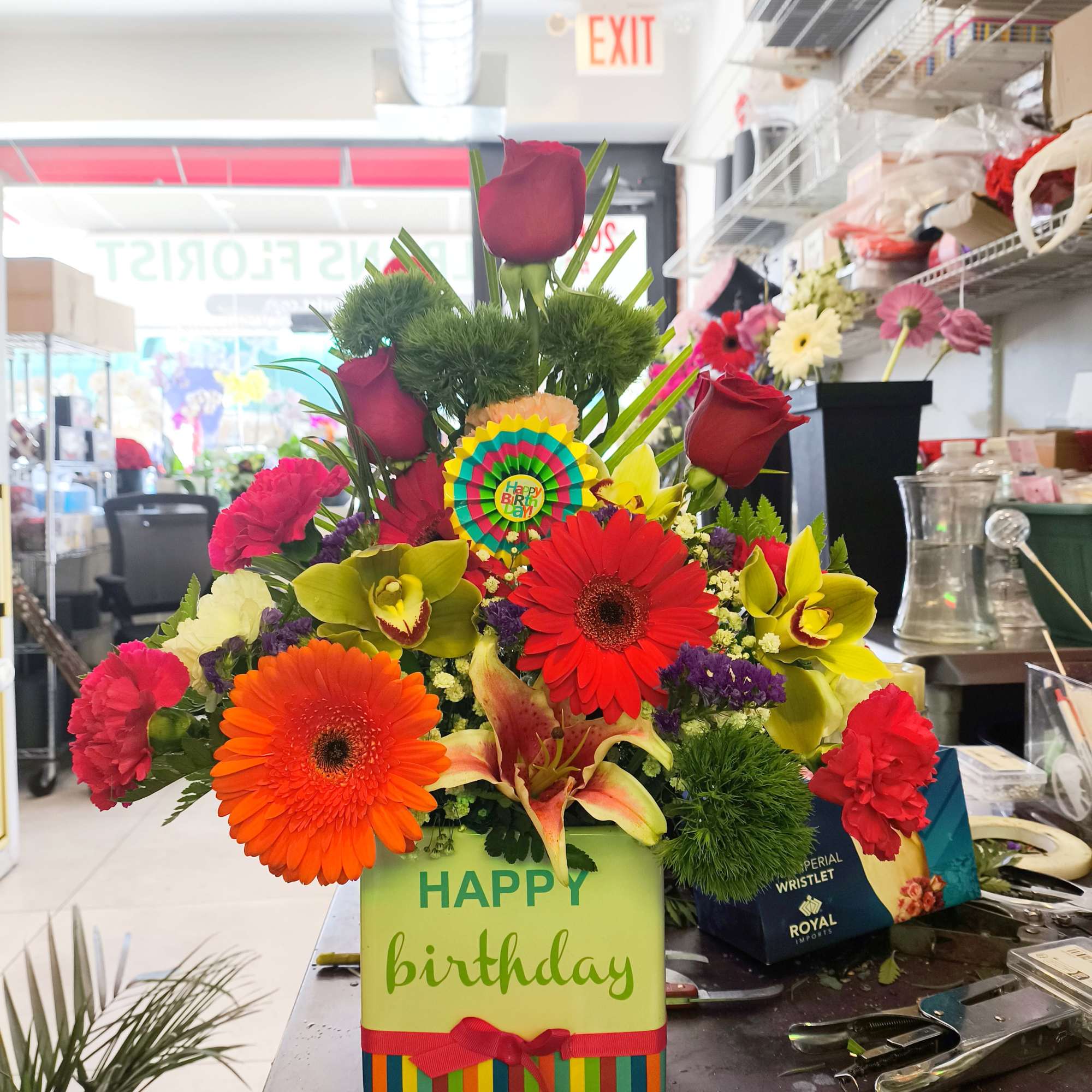 Colorful birthday flower arrangement with gerbera daisies and roses in a gift box
