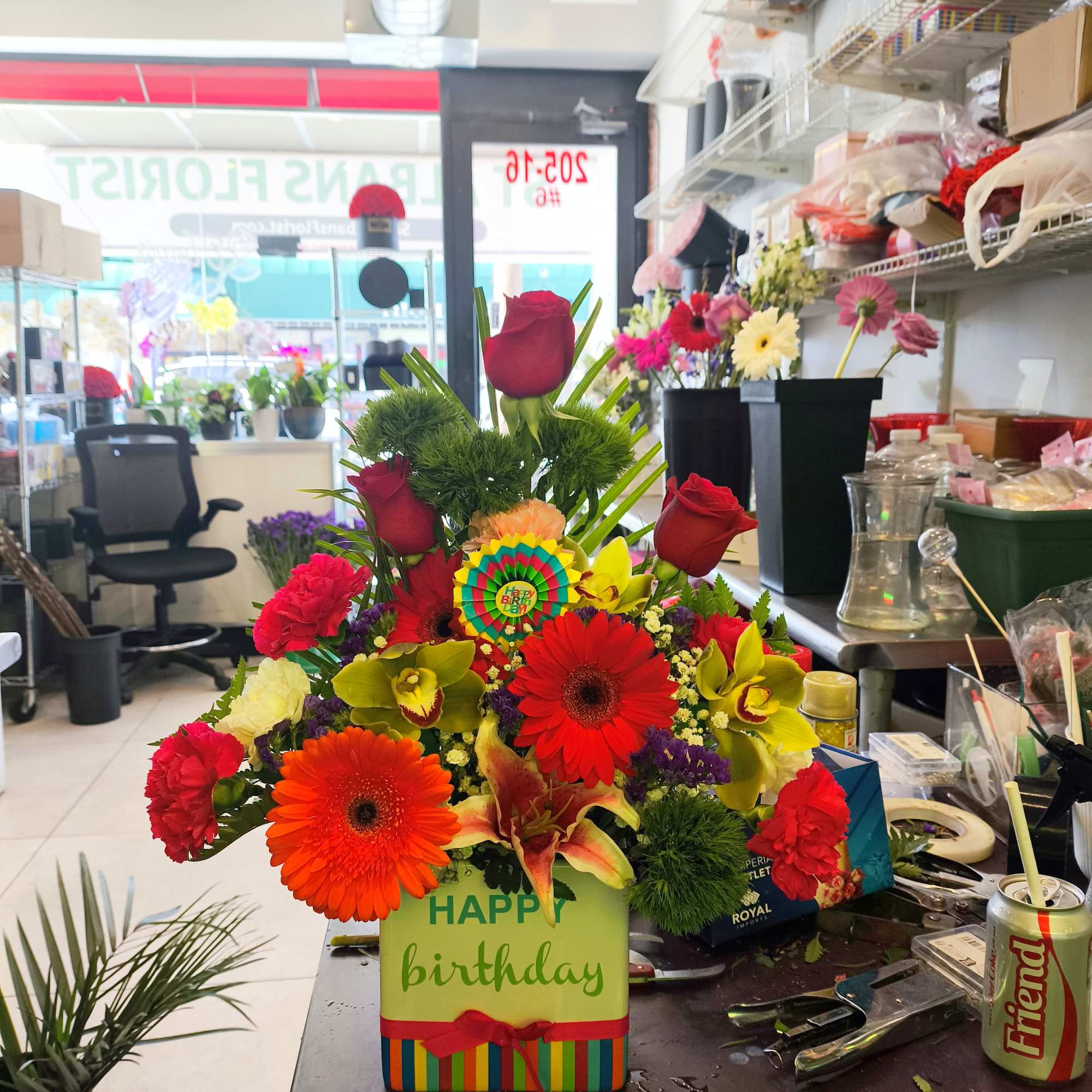 Birthday flower arrangement in a gift box with red roses and bright gerbera daisies