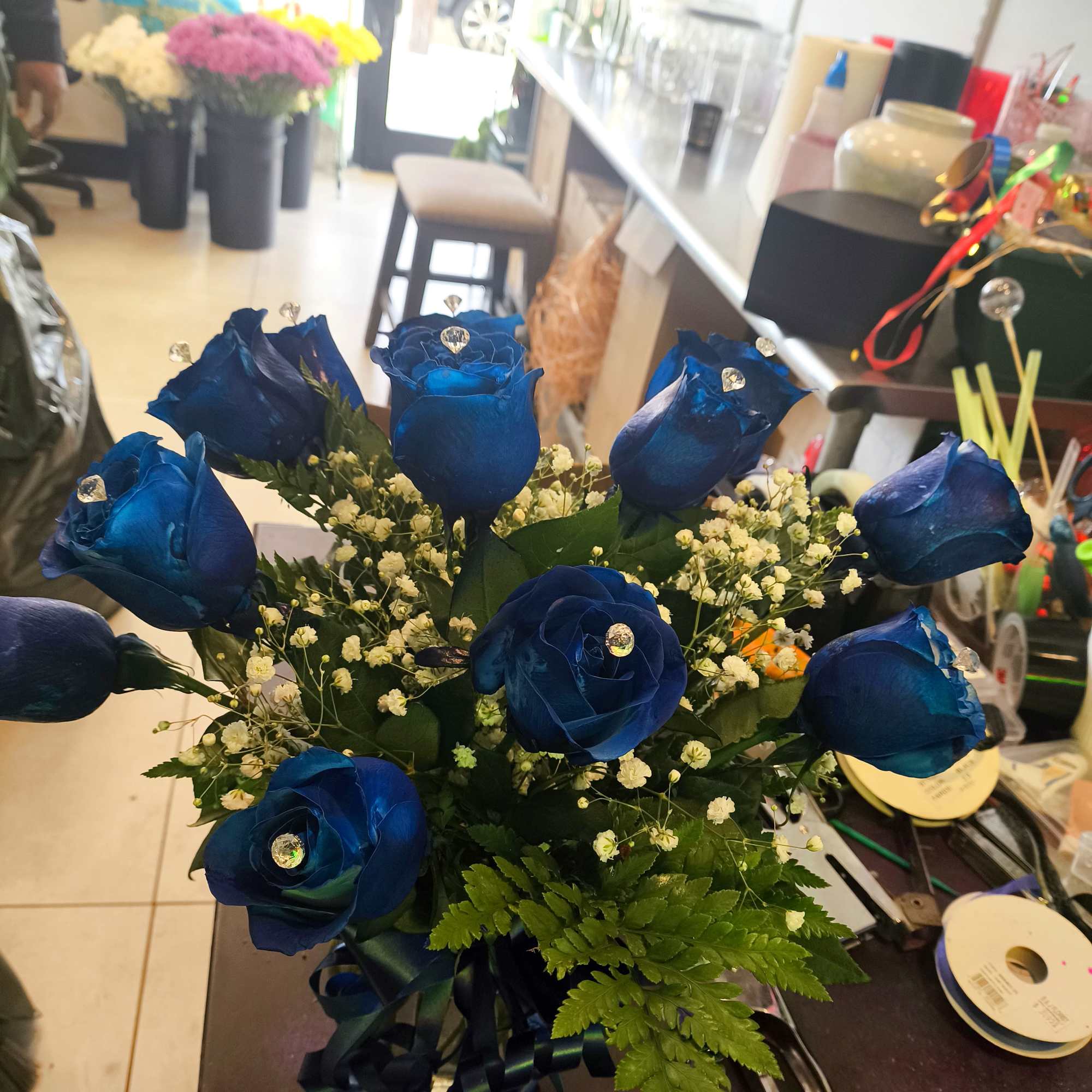 Blue roses arranged with baby's breath and ribbon