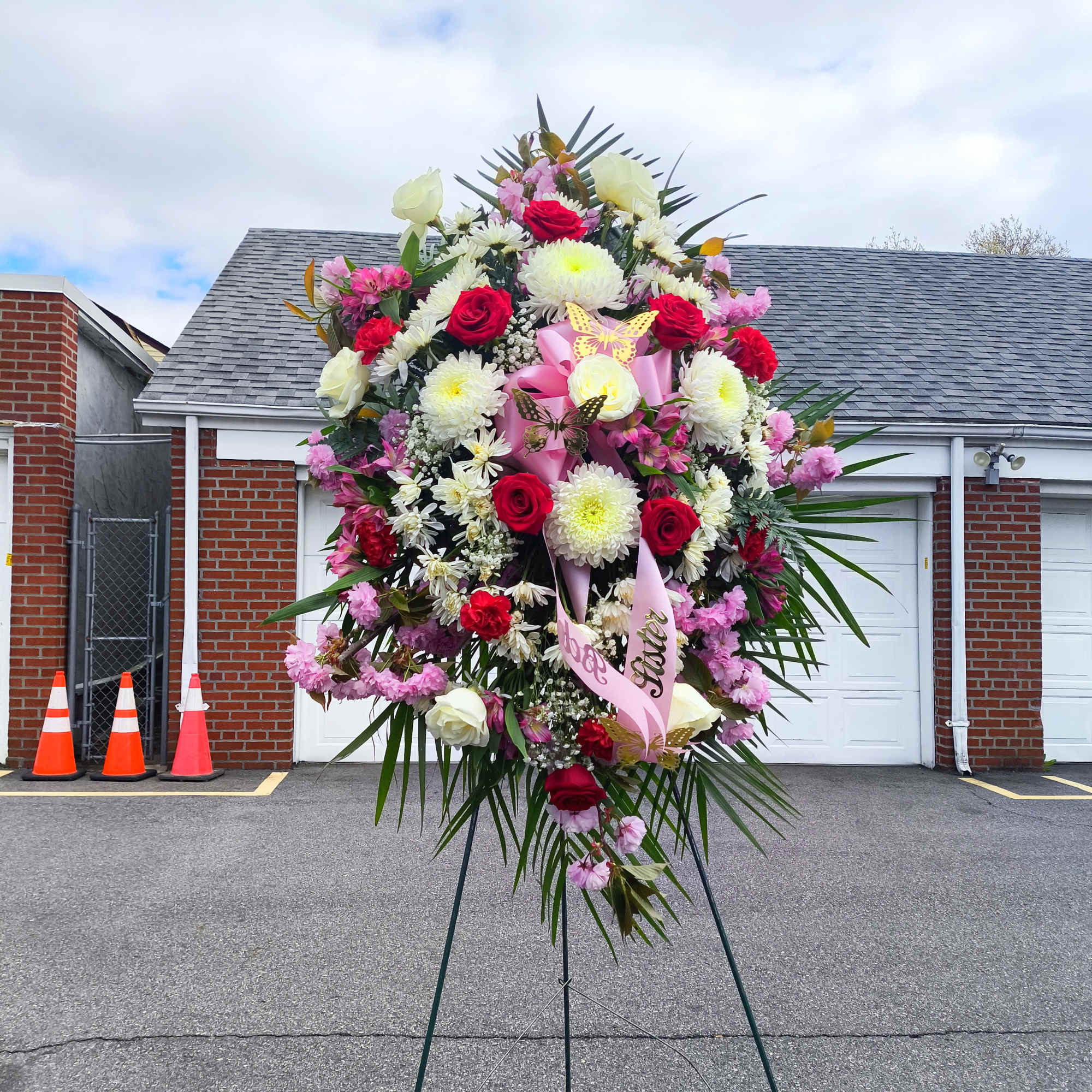 Large standing floral spray with red and white flowers on an easel