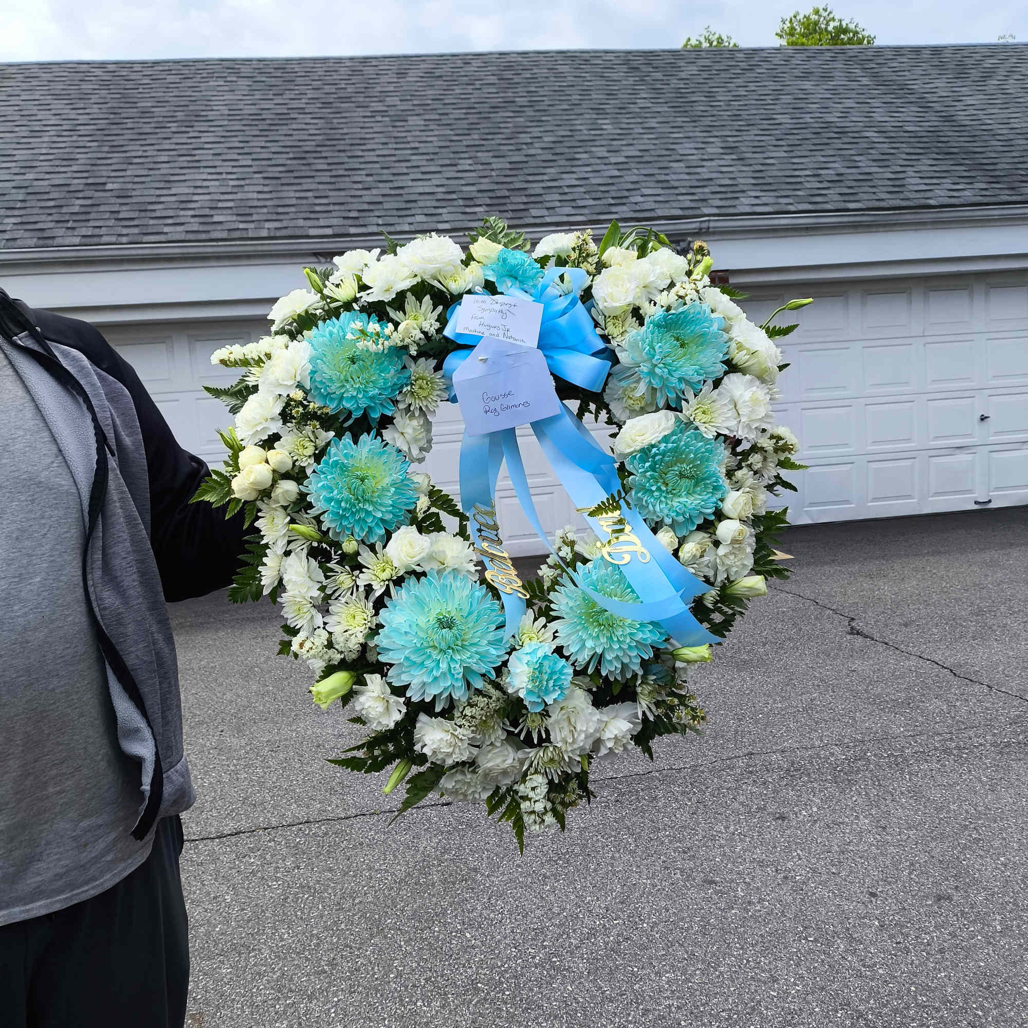 Heart-shaped white and turquoise floral wreath with blue ribbon