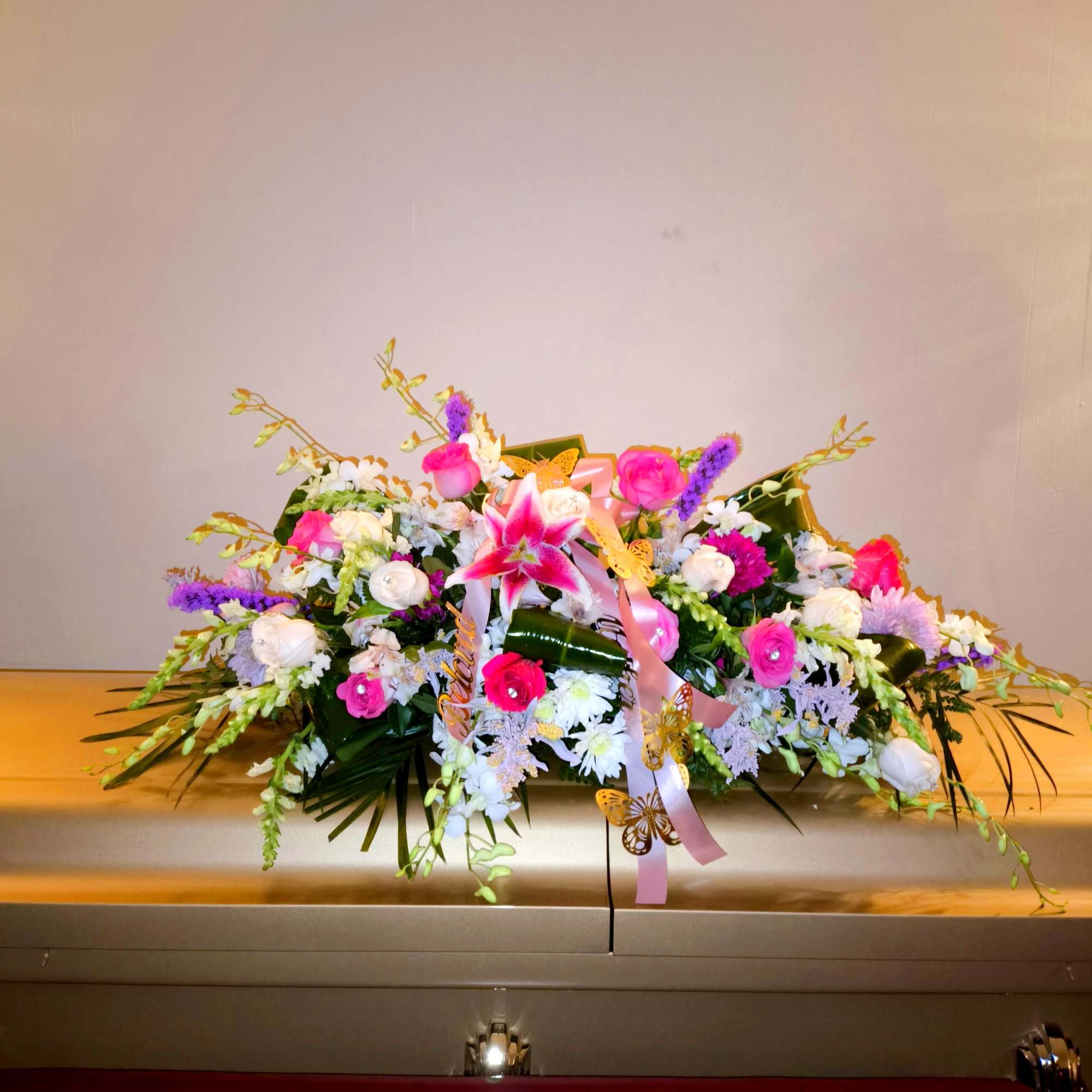 Large floral casket spray with pink, white, and purple flowers