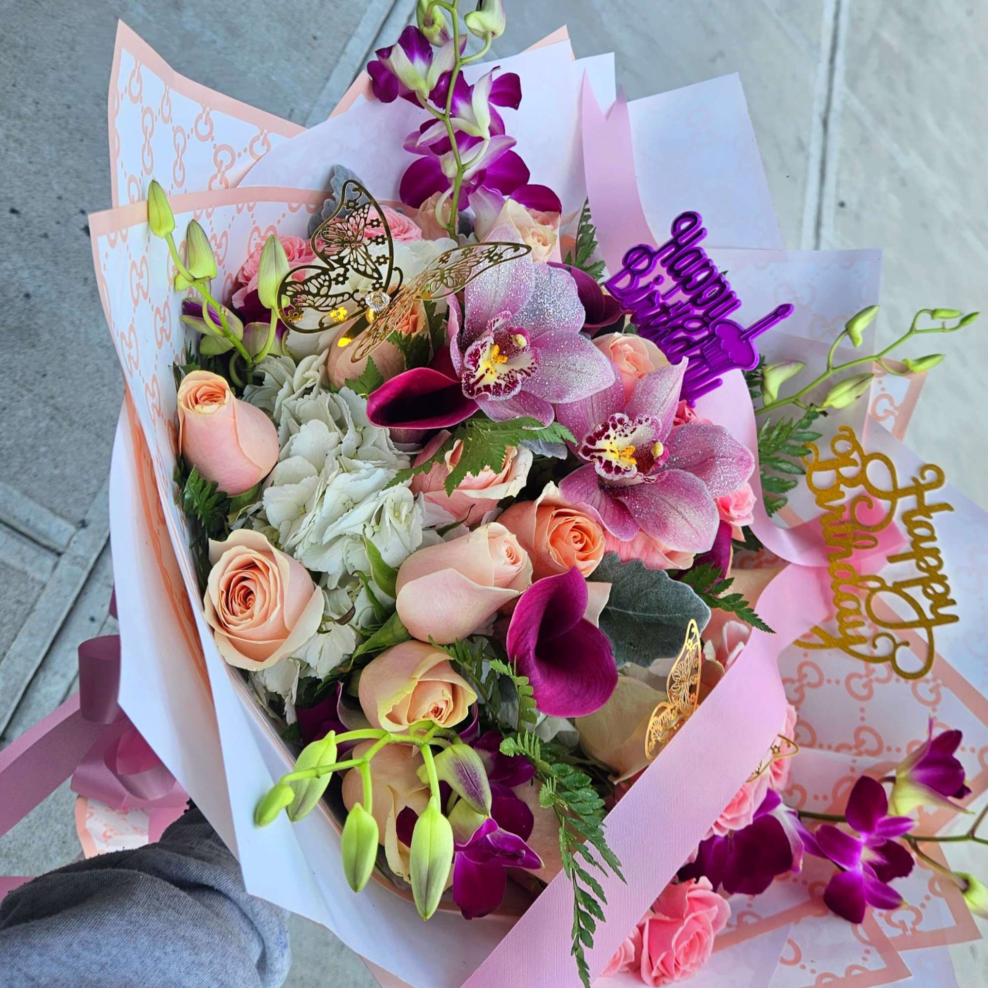 Bouquet of pink roses and purple orchids with birthday picks