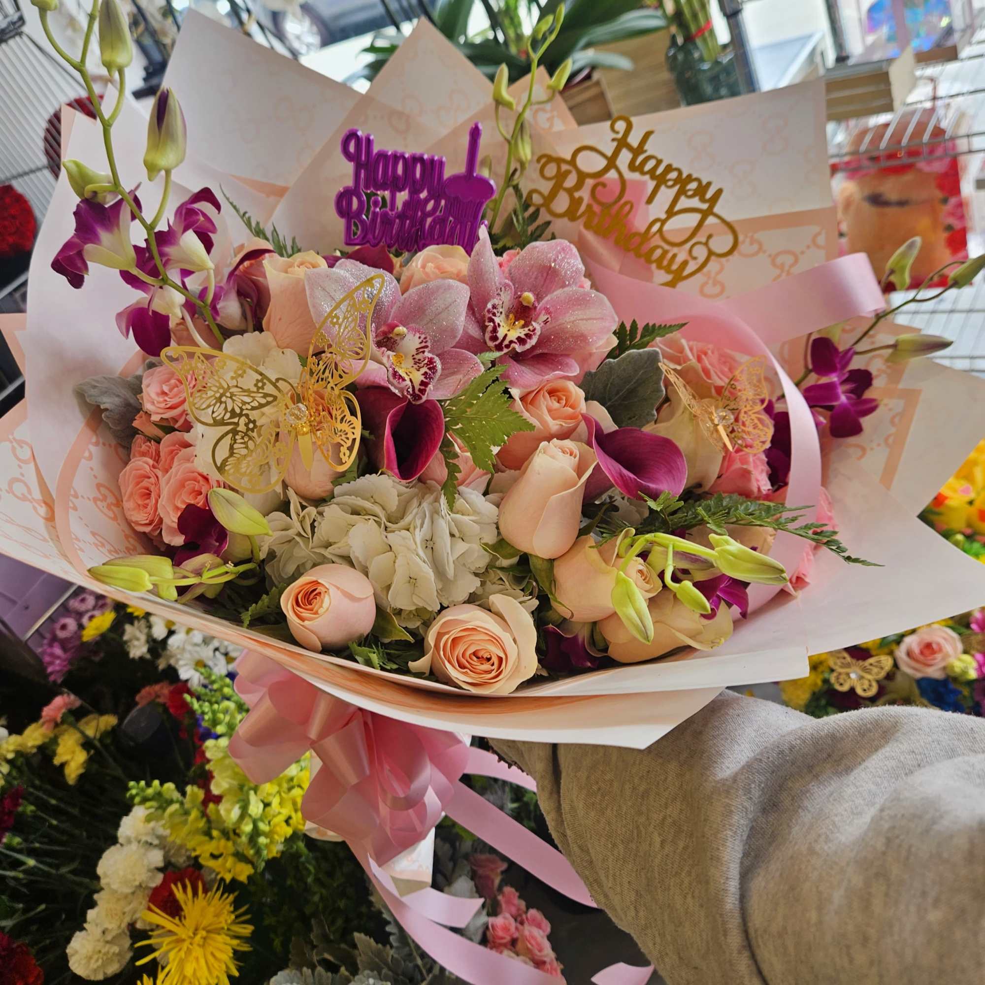 Bouquet of pink roses and orchids with birthday topper