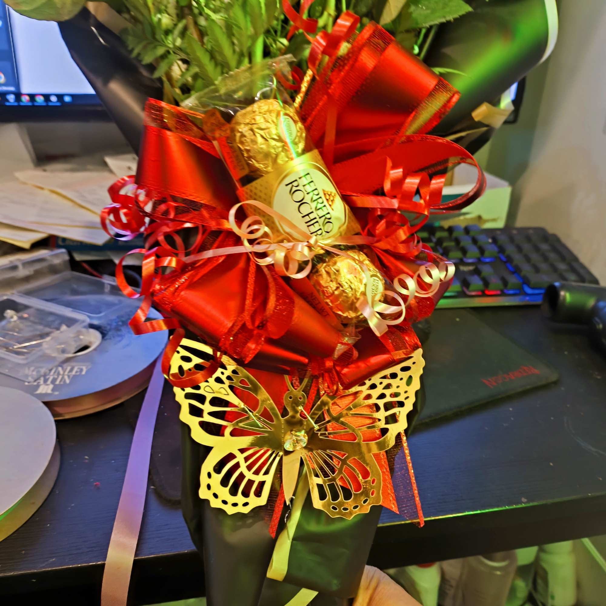 Bouquet with red ribbon, Ferrero Rocher chocolates, and a gold butterfly decoration