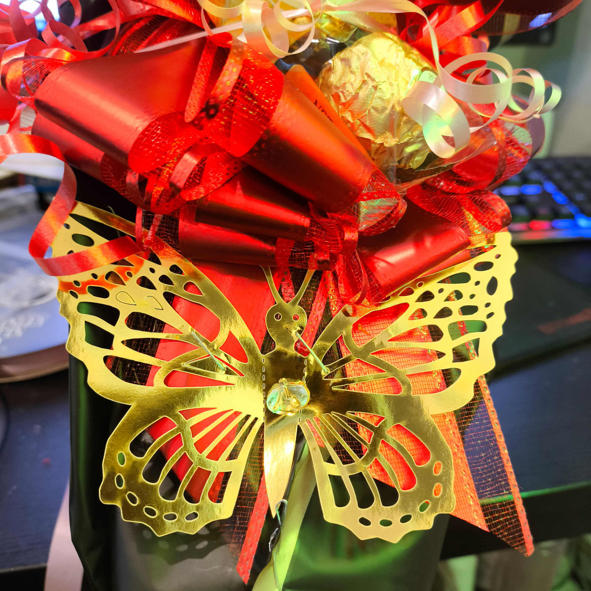 Gift basket wrapped with red ribbons and a gold butterfly decoration