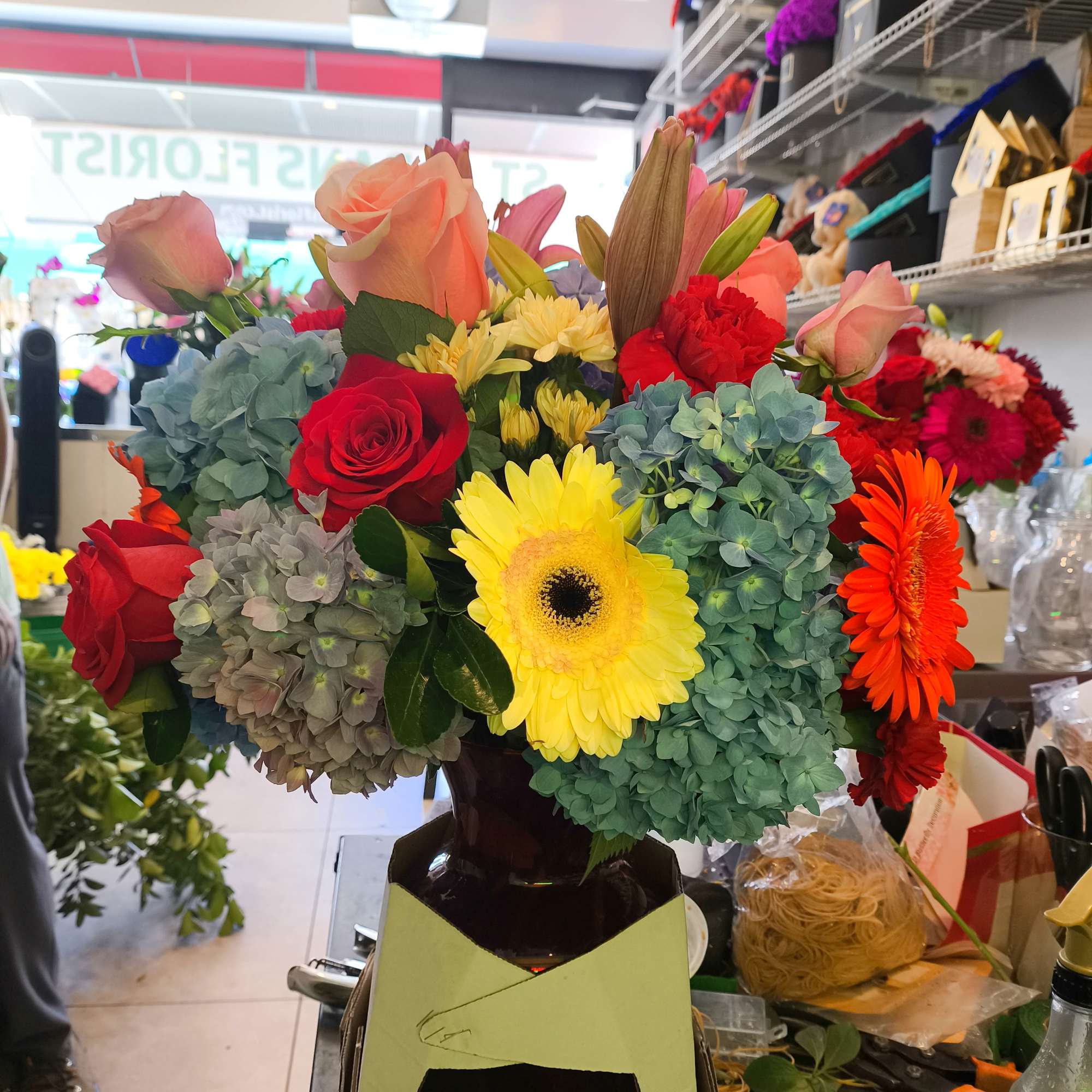 Mixed bouquet of roses, gerbera daisies, and hydrangeas in a vase