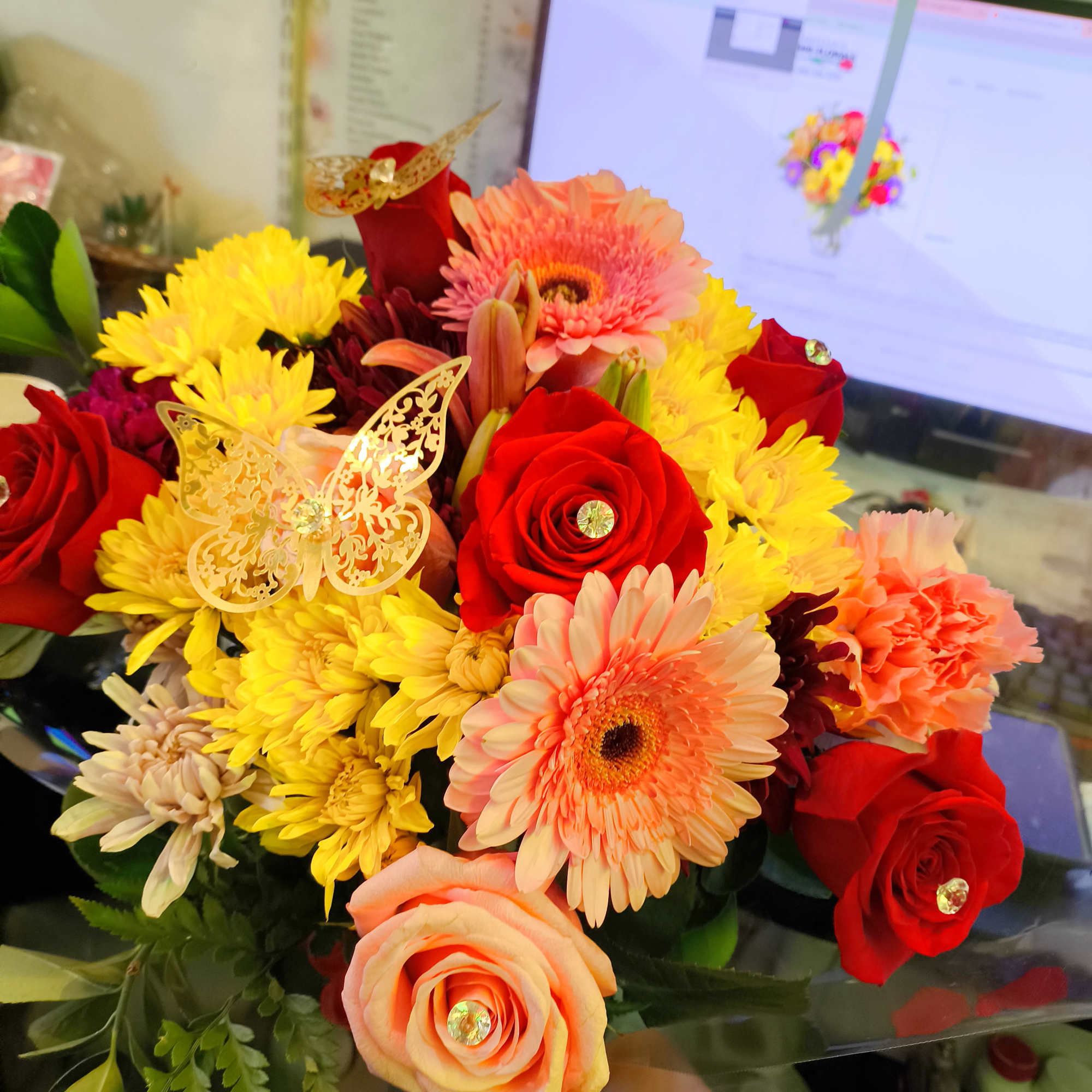 Bouquet of red and peach roses with yellow and pink daisies