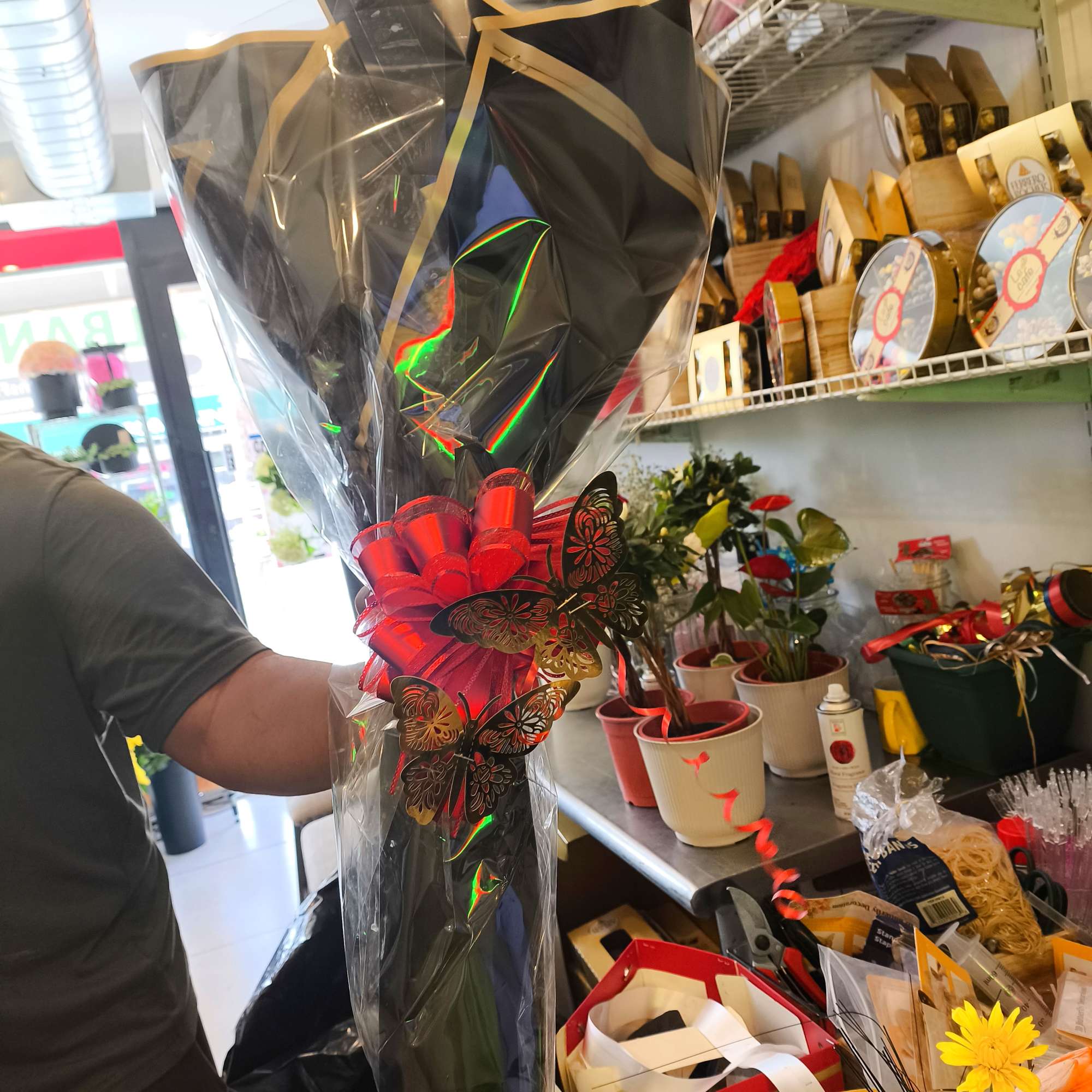 Wrapped bouquet with a large red bow and black paper