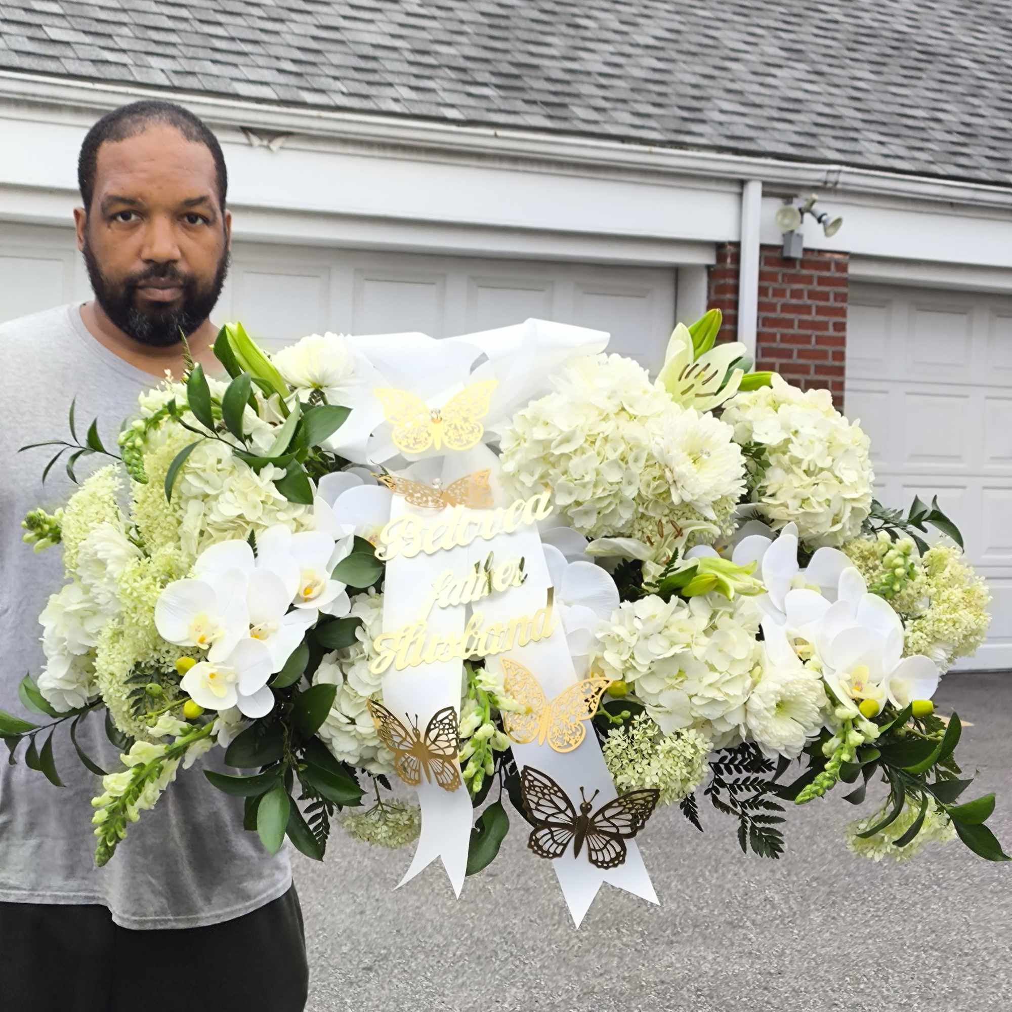 Large white floral arrangement with orchids and hydrangeas, decorated with butterfly ribbons, photo 2 of 5
