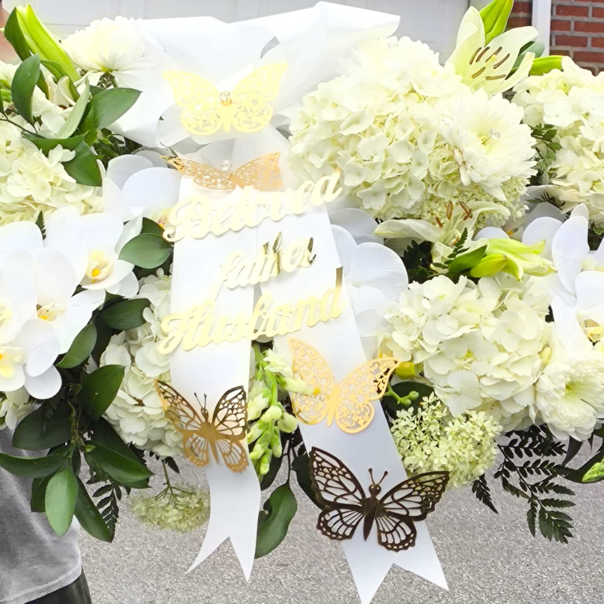 Large white floral arrangement with orchids and hydrangeas, decorated with butterfly ribbons, photo 3 of 5