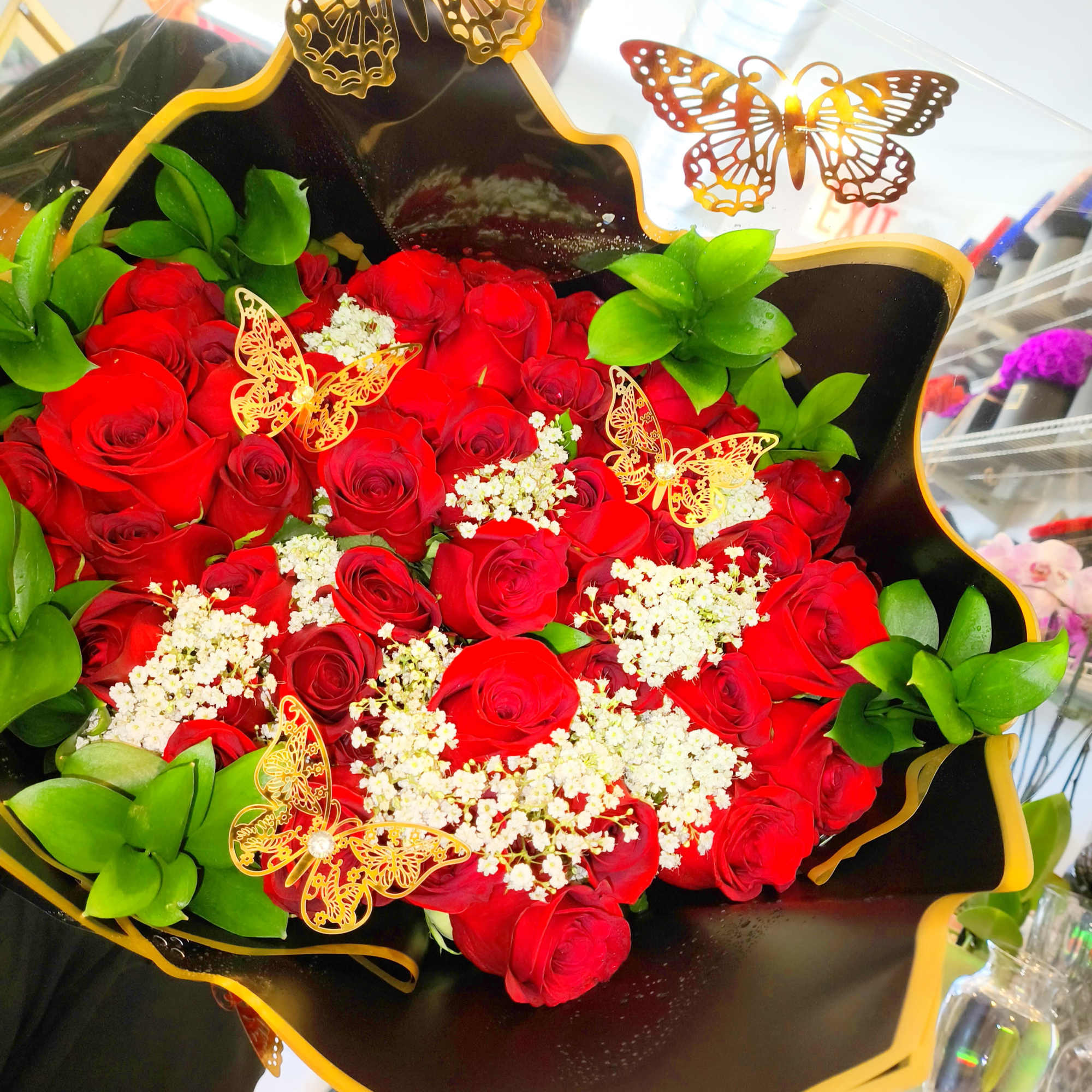 Bouquet of red roses with white filler and butterfly decorations